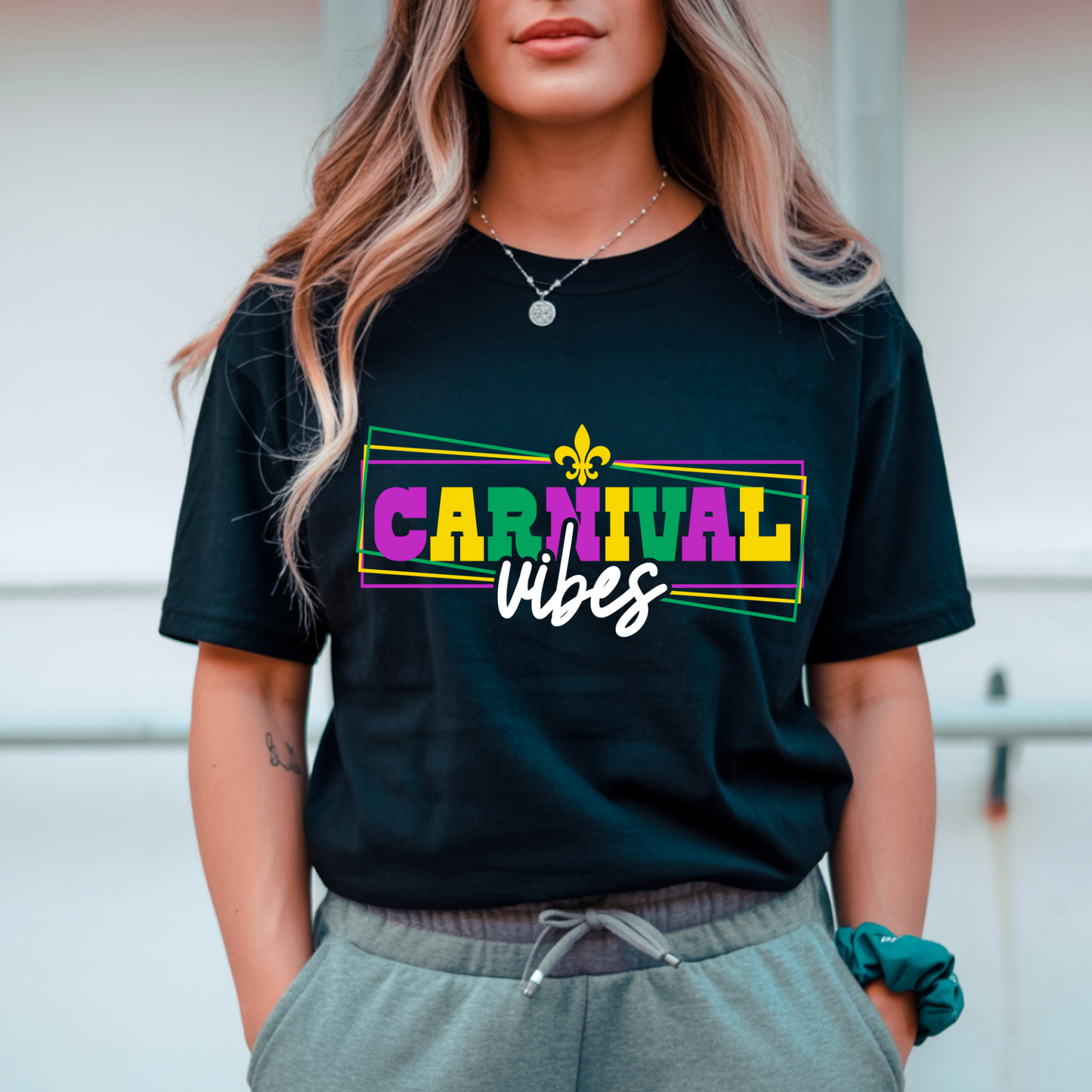 Person wearing a black t-shirt with 'Carnival vibes' text and colorful design.