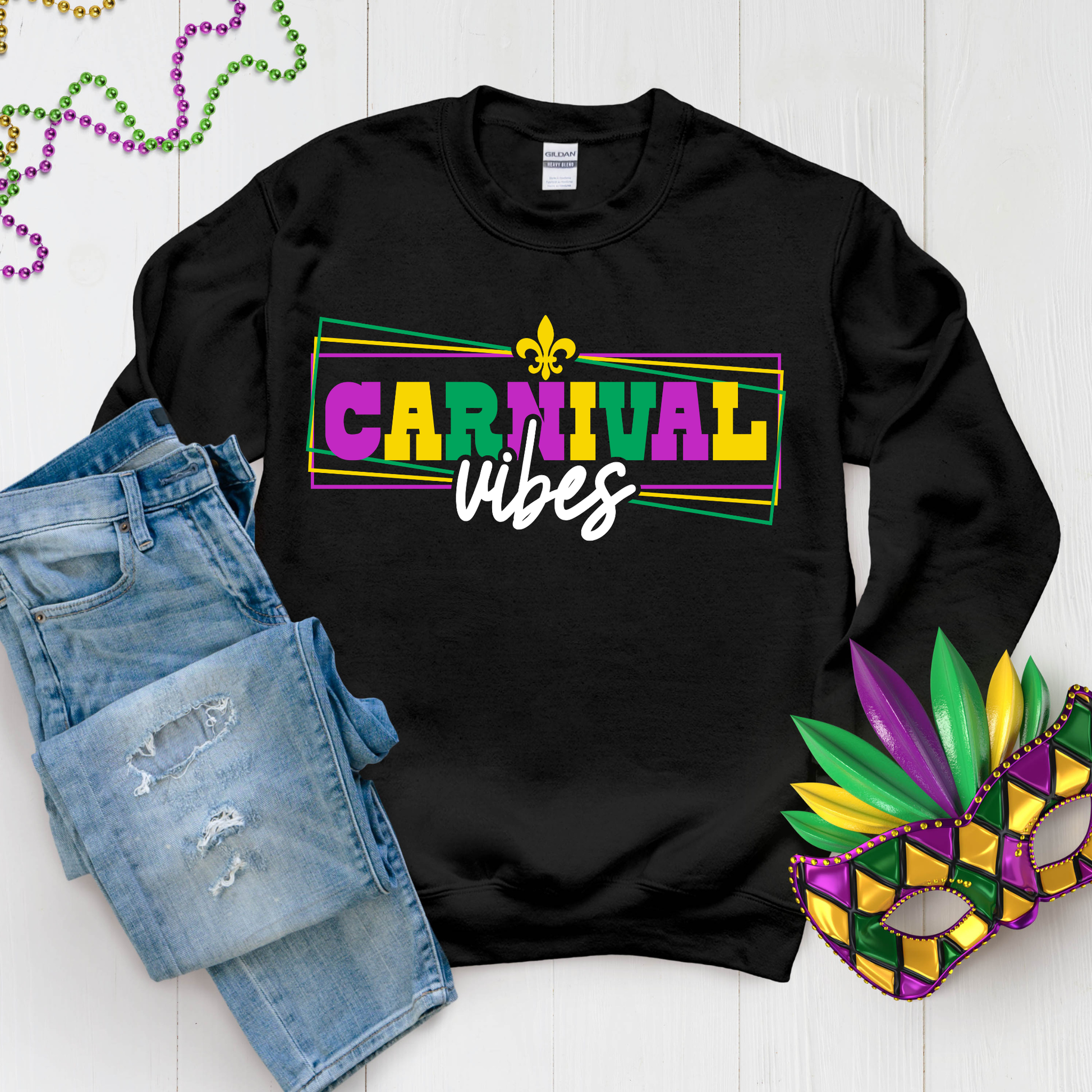Black sweatshirt with 'Carnival Vibes' text, denim shorts, and Mardi Gras mask on a white background