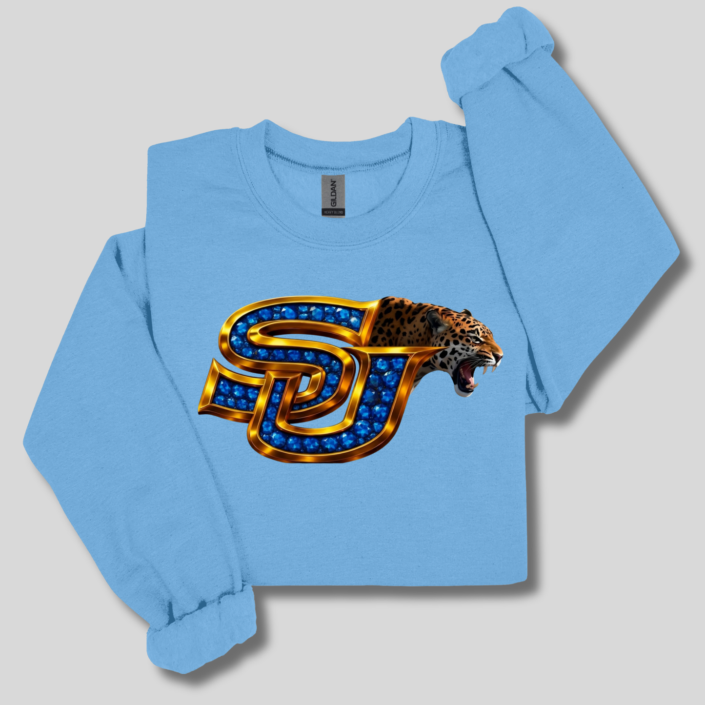 A light blue long-sleeve sweatshirt with a graphic of a roaring leopard integrated into a large metallic gold and blue 'SJ' monogram, displayed on a neutral gray background.