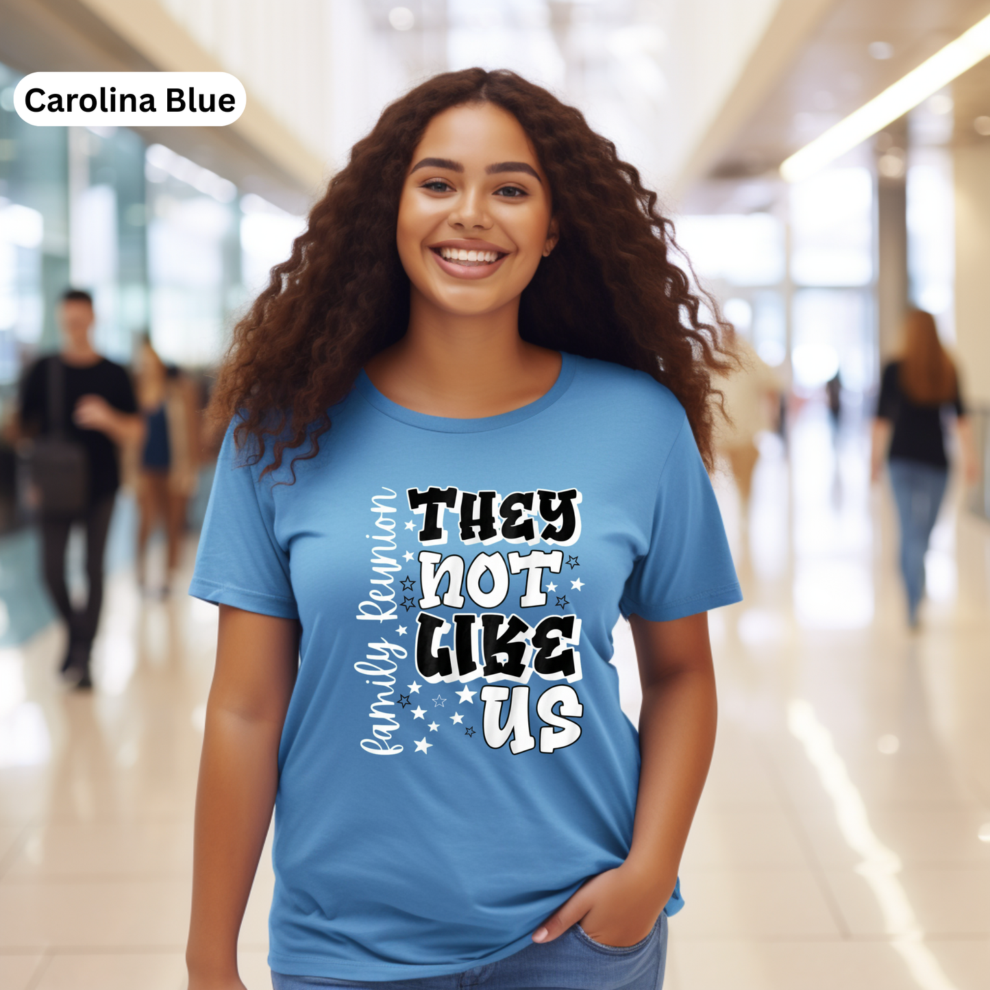 Woman wearing a blue t-shirt with text in a modern indoor setting