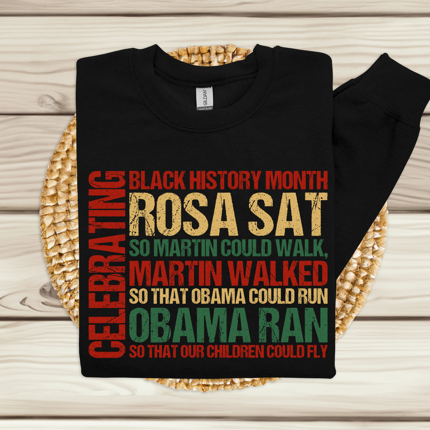 Black t-shirt with colorful text on a woven mat