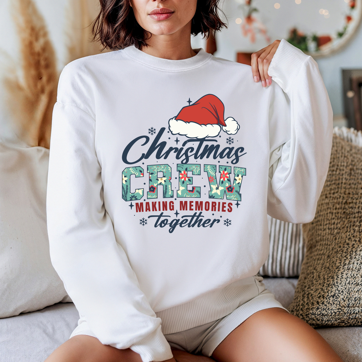 Person wearing a white sweatshirt with Christmas-themed text and graphics