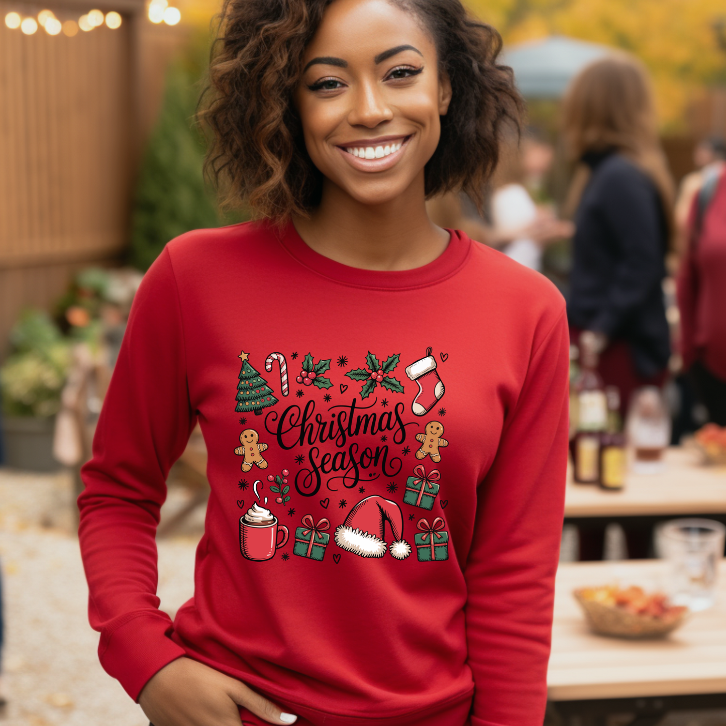 Woman wearing a red 'Christmas Season' sweater in an outdoor setting.
