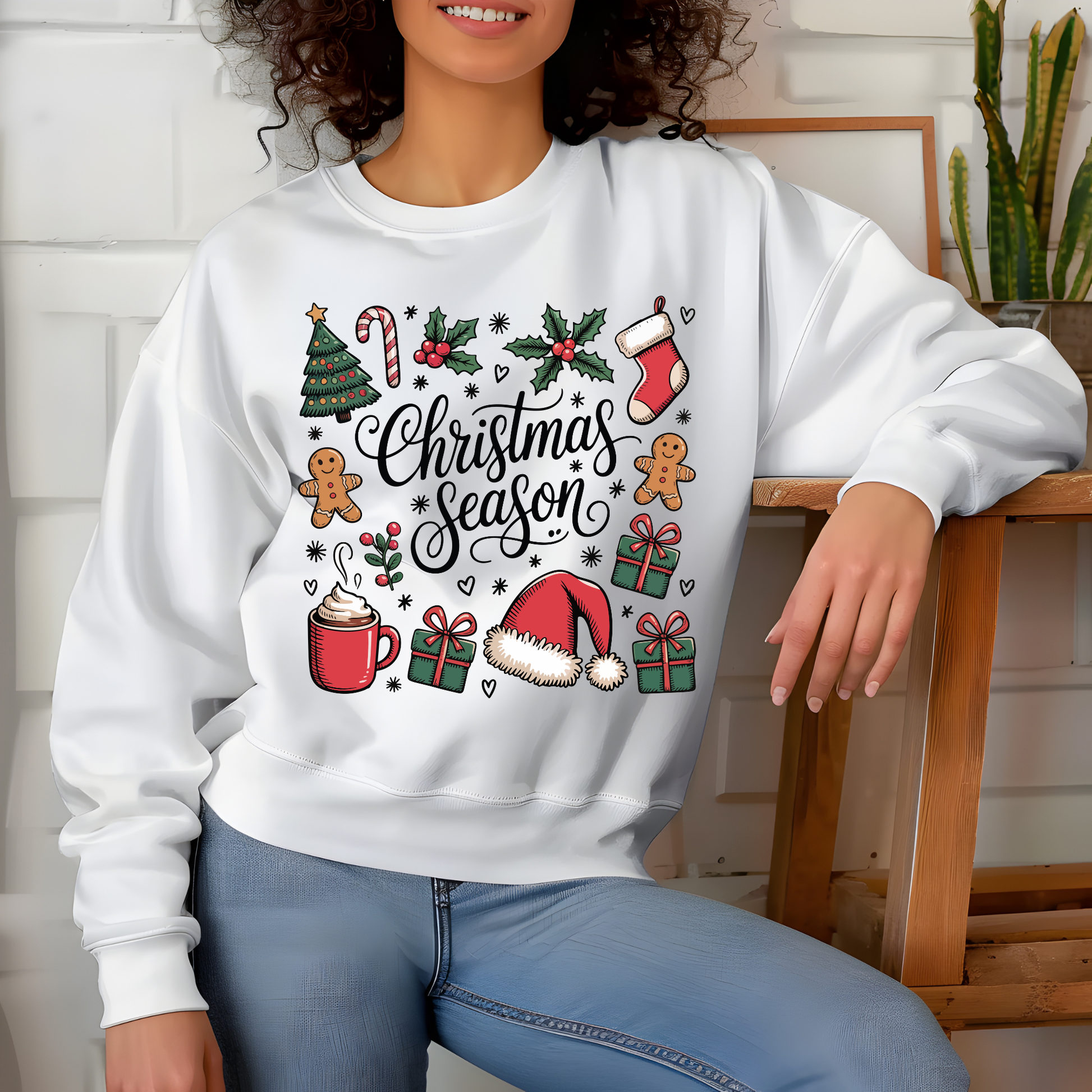 Person wearing a white sweatshirt with Christmas-themed graphics and text.