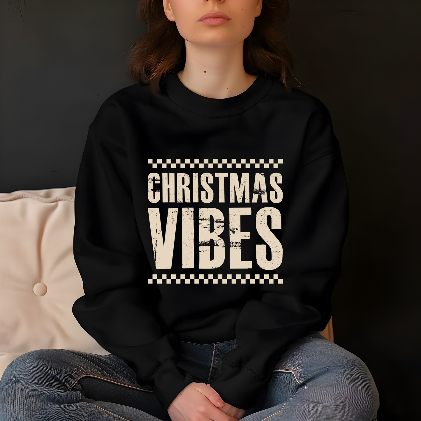Person wearing a black sweatshirt with 'Christmas Vibes' text sitting on a couch.
