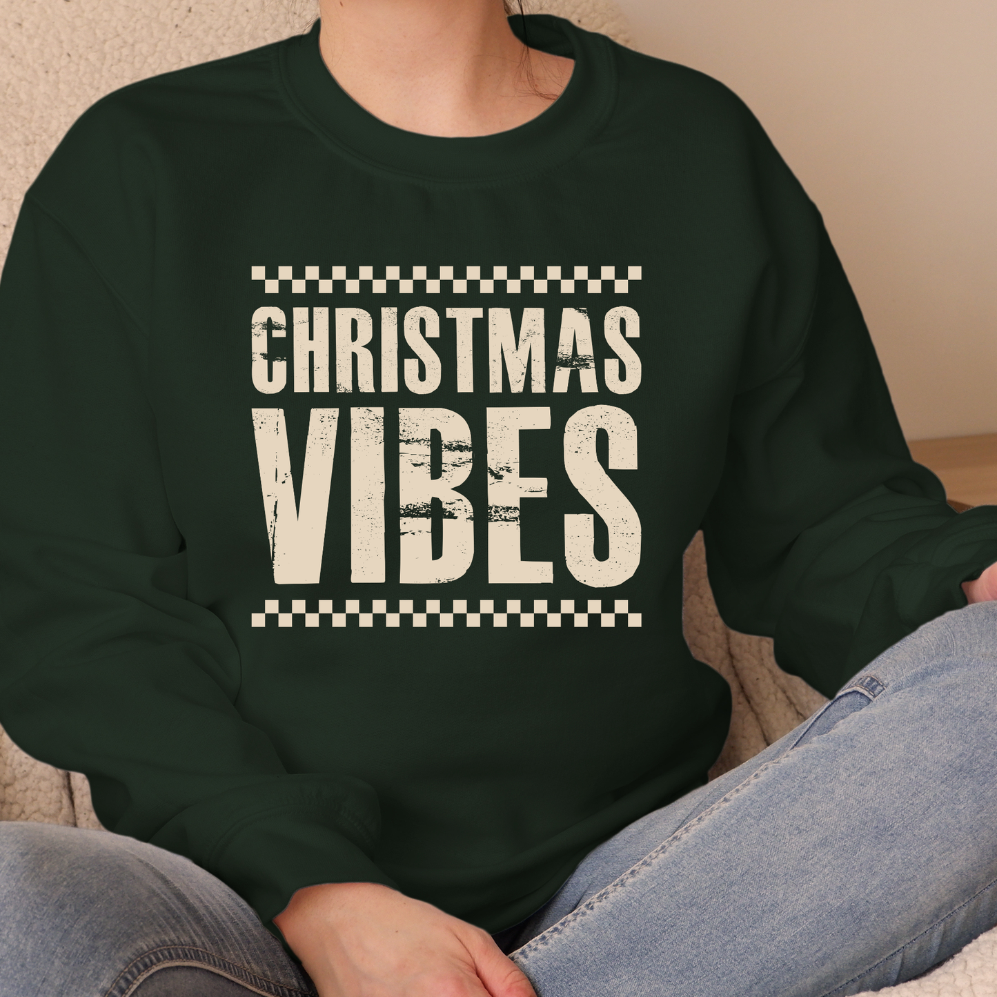 Person wearing a dark green sweatshirt with 'Christmas Vibes' text.