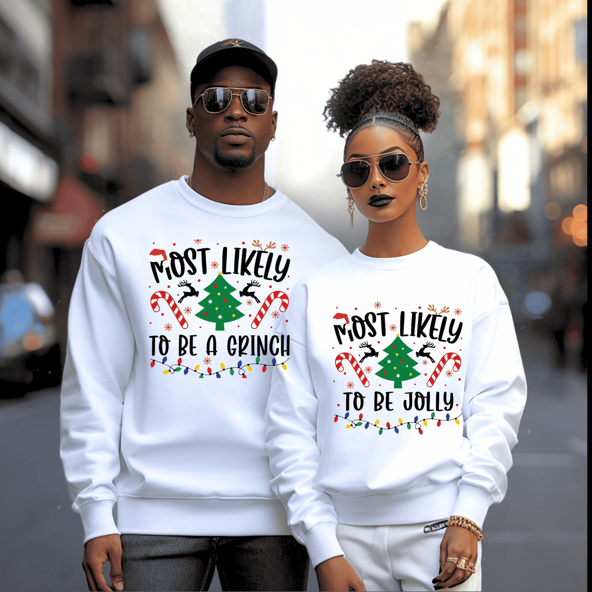 A man and a woman standing together on a city street, both wearing matching white crewneck sweatshirts with a festive Christmas graphic that reads 'MOST LIKELY TO BE A GINCH' and 'TO BE JOLLY' with candy canes, a Christmas tree, and holiday lights.