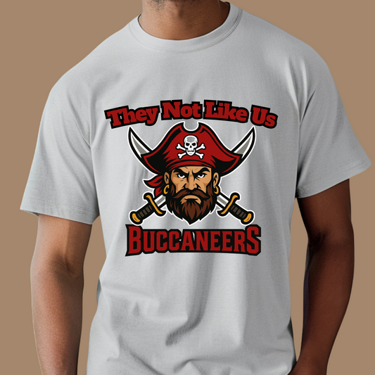Person wearing a white t-shirt with a Buccaneers logo and text on a brown background Custom Mascot Shirt - Buccaneers They Not Like Us Game Day Wear