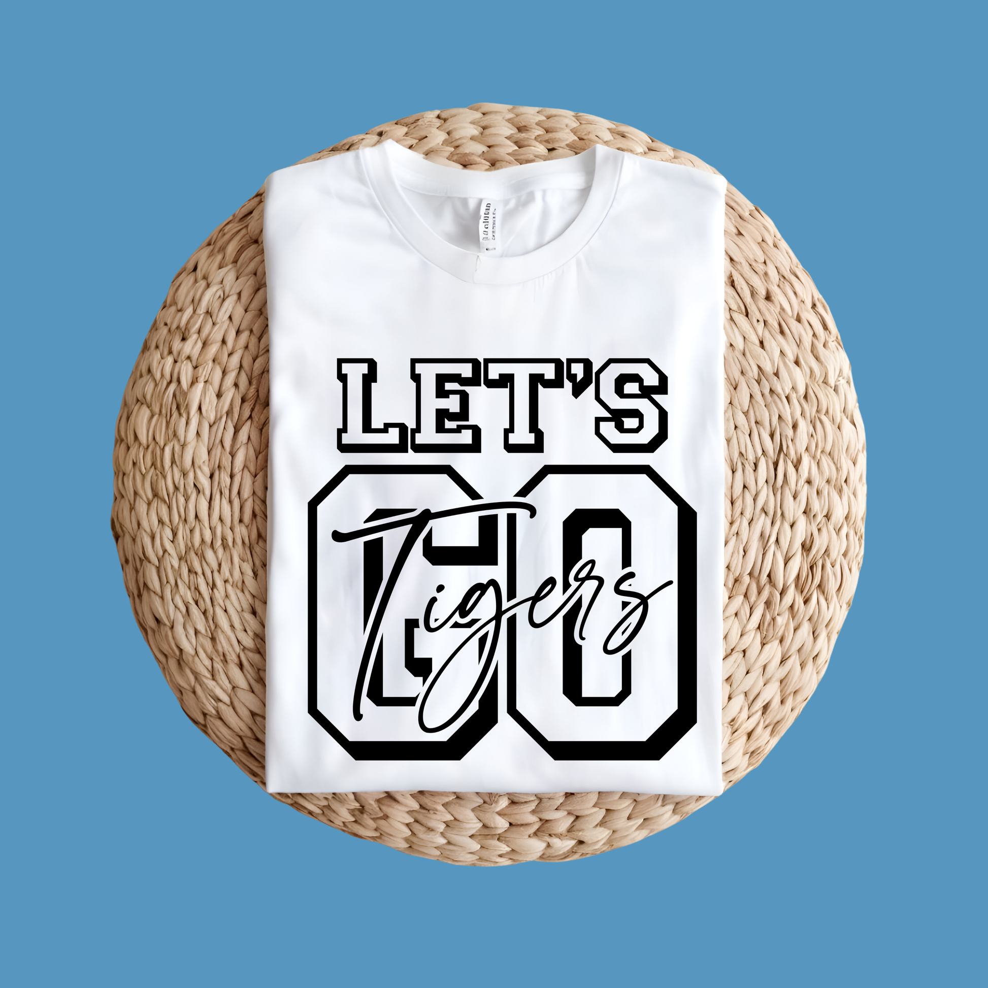 White t-shirt with 'Let's Go Tigers' text on a woven mat against a blue background, Custom Mascot Shirt - Let's Go Tigers Game Day Spirit Wear