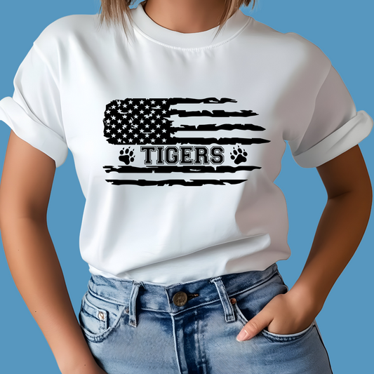 Person wearing a white t-shirt with a black American flag and 'TIGERS' design on a blue background, Custom Mascot Shirt - Tigers American Flag School Spirit Tee Shirt