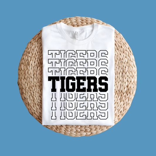 White t-shirt with 'TIGERS' text design on a woven stool against a blue background, Custom Mascot Shirt - Tigers Pride Game Day Cool School Spirit Tee