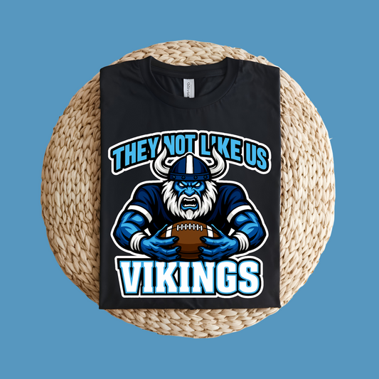 Black t-shirt with Viking graphic and text on a woven surface Custom Mascot Shirt - Vikings They Not Like Us Game Day Wear