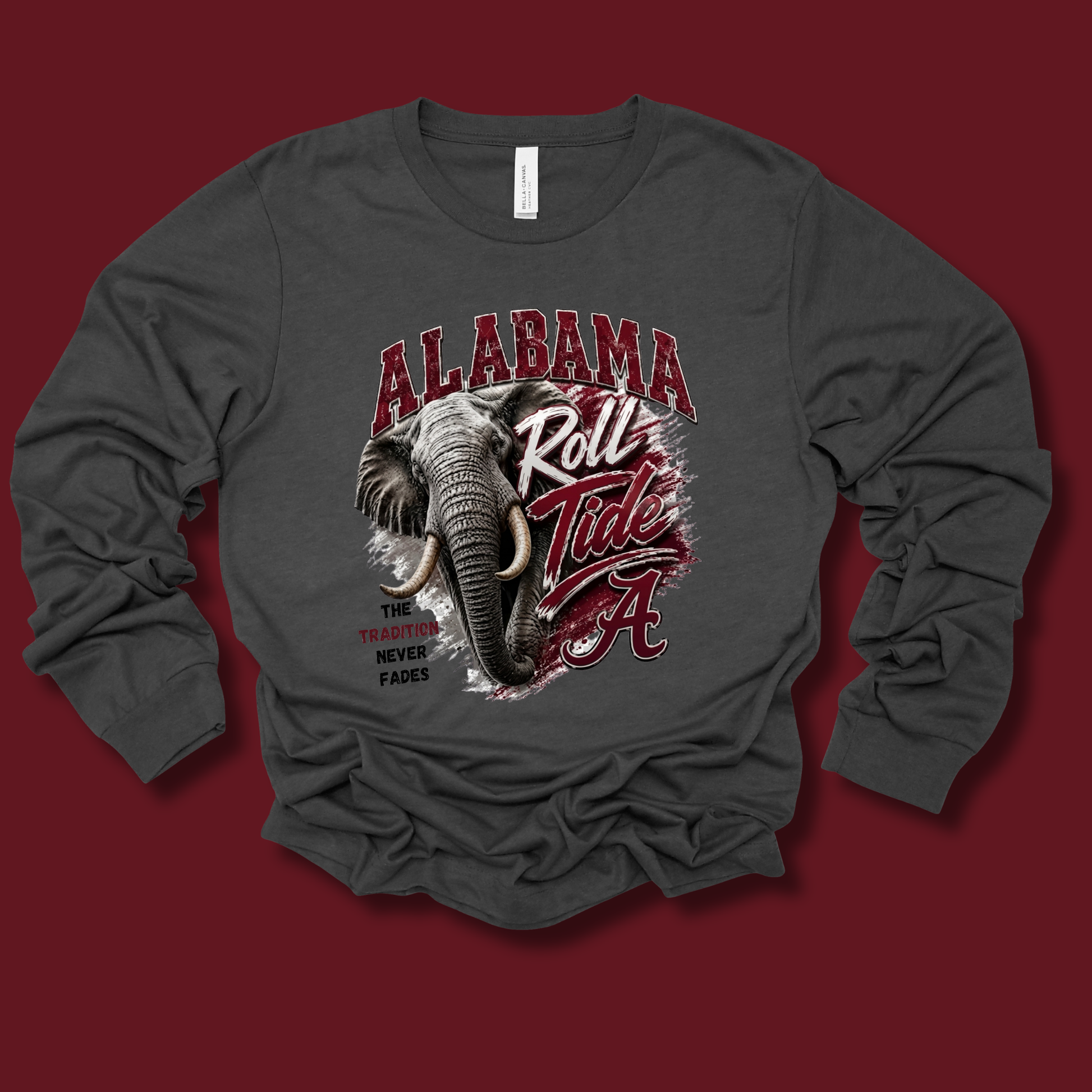 A dark gray long-sleeve t-shirt with a graphic print of an elephant and the text 'ALABAMA Roll Tide' in red and white, displayed on a solid dark red background.