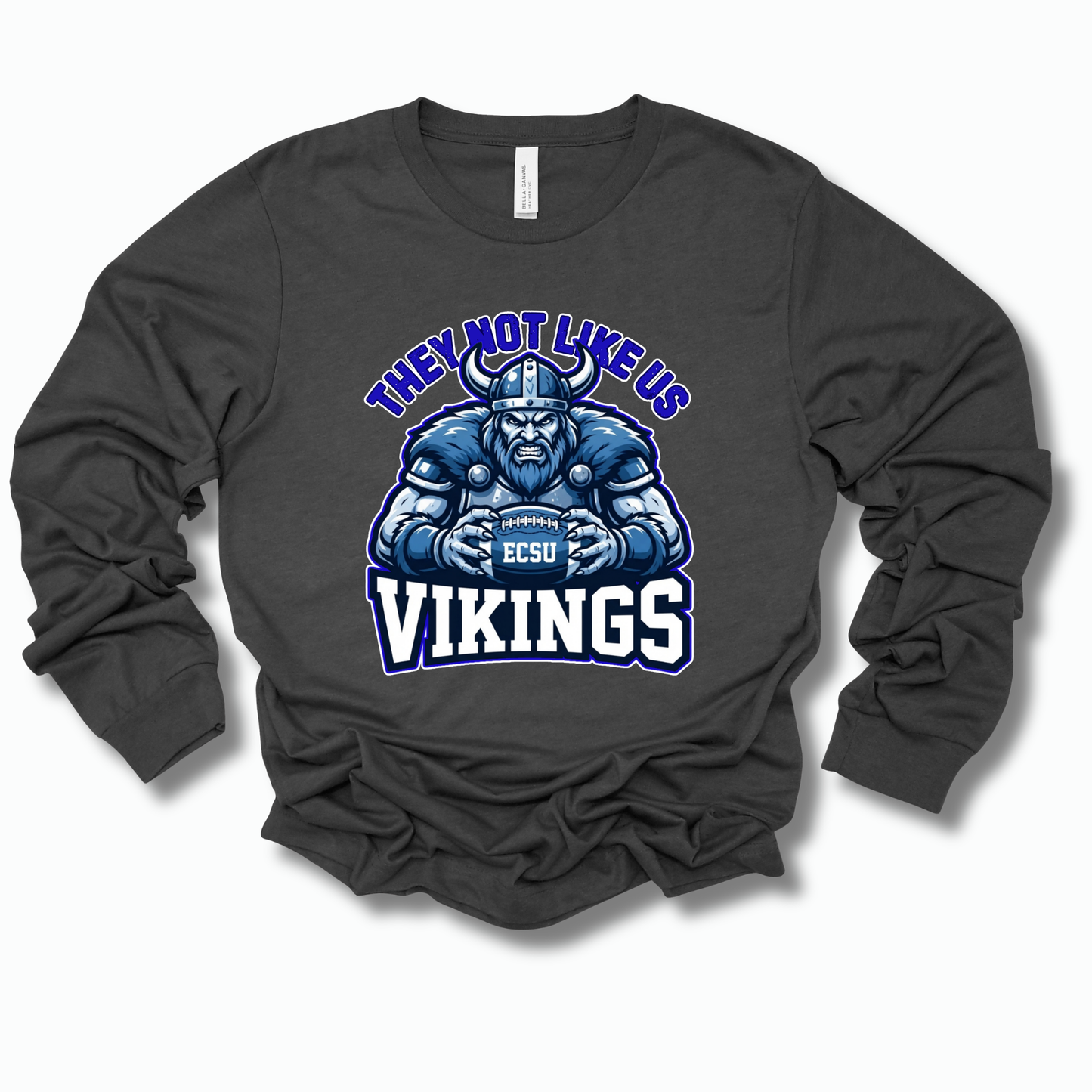 A dark charcoal gray long-sleeve t-shirt with a graphic of a blue and white Viking holding a football that reads 'ESCU', with the text 'THEY NOT LIKE US' above and 'VIKINGS' below.