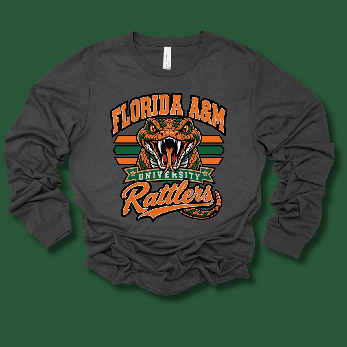 A dark gray long-sleeve t-shirt with a graphic print of an orange and green rattlesnake head and the text 'FLORIDA A&M UNIVERSITY Rattlers' on the front, displayed against a solid dark green background.