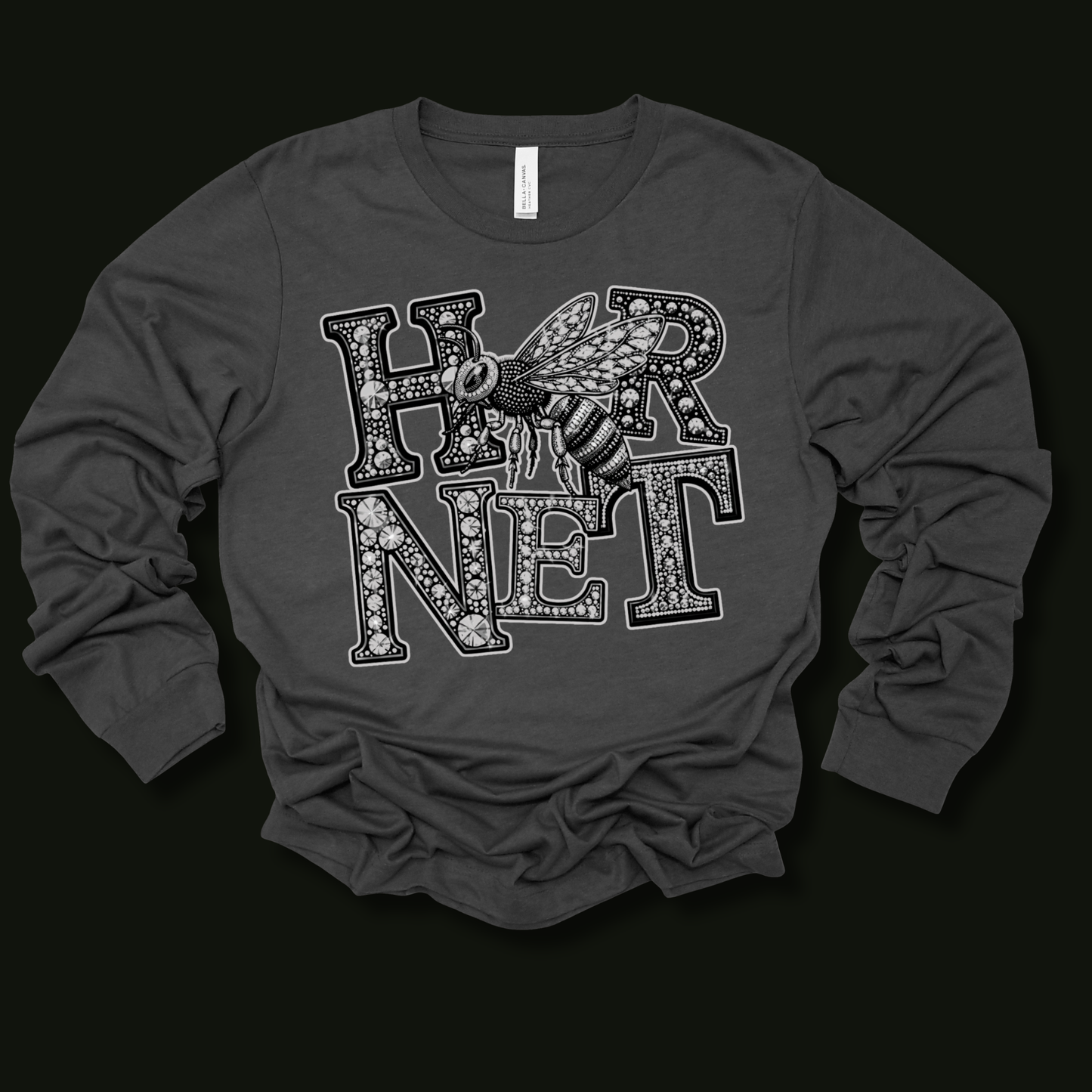 A dark gray long-sleeve t-shirt with a graphic print of the word 'HORNET' in a patterned font with a bee overlay, displayed on a solid black background.