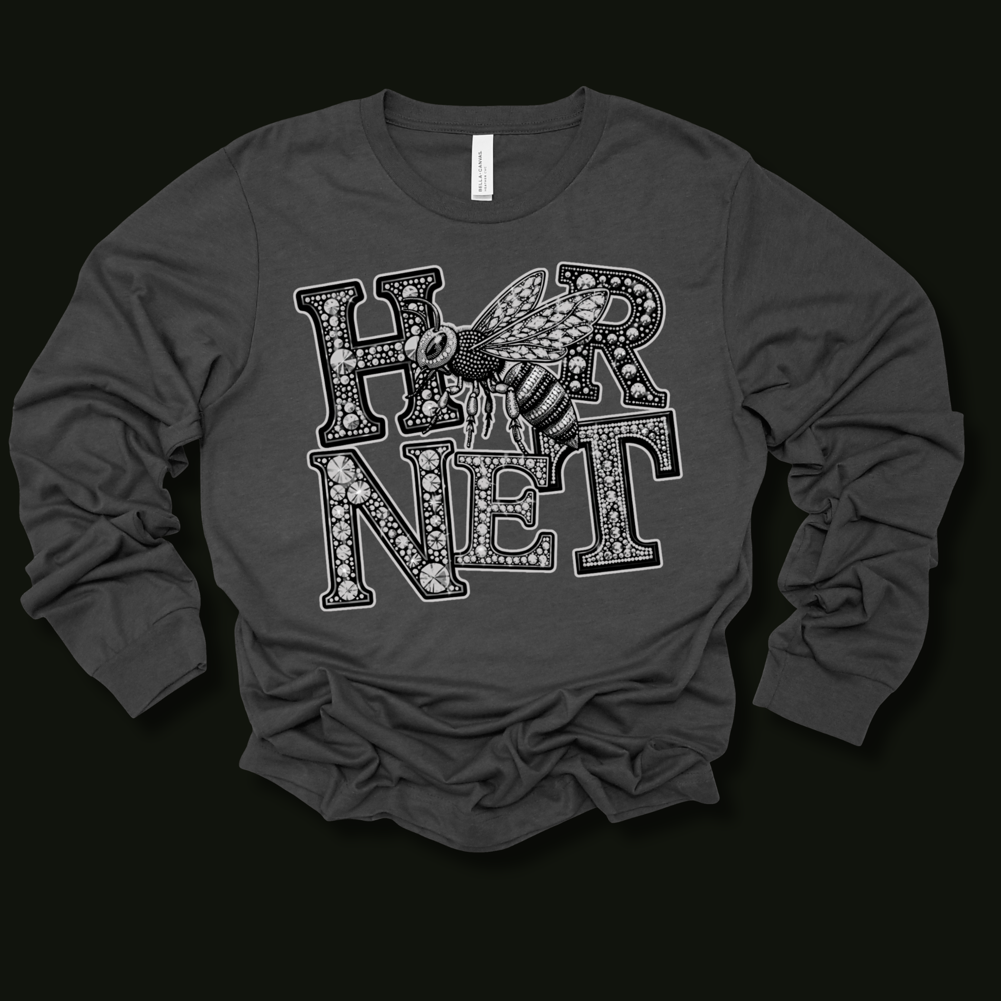 A dark gray long-sleeve t-shirt with a graphic print of the word 'HORNET' in a patterned font with a bee overlay, displayed on a solid black background.