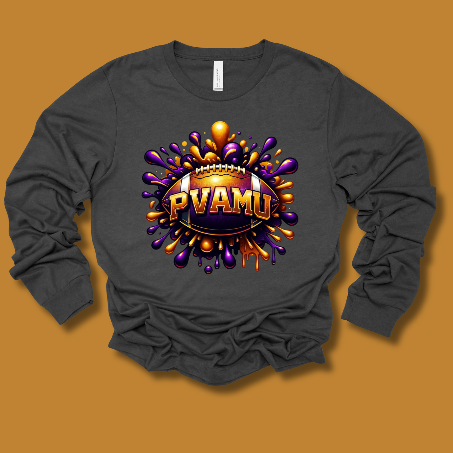 A dark gray long-sleeve t-shirt with a colorful graphic print of a football surrounded by purple and orange paint splatters, featuring the text 'PVAMU'.