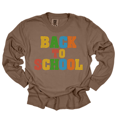 A brown long-sleeve t-shirt with a colorful graphic reading 'BACK TO SCHOOL' in striped letters, displayed flat against a white background.