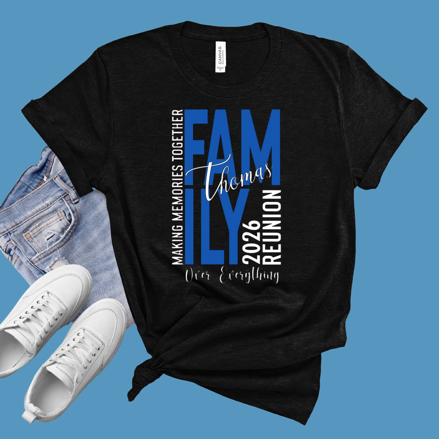 Black t-shirt with 'Family Reunion 2026' text on a blue background, with jeans and white sneakers.