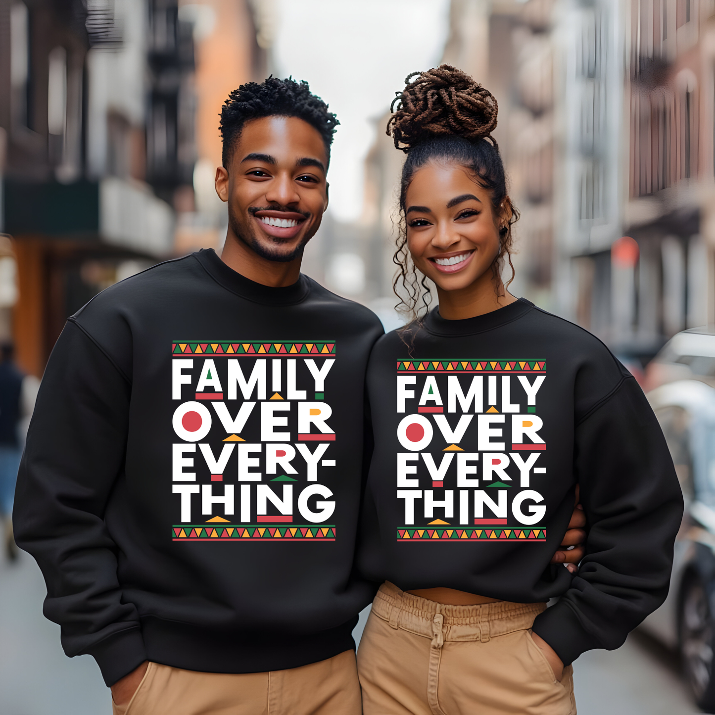 Two people wearing black sweatshirts with 'Family Over Everything' text on a city street.