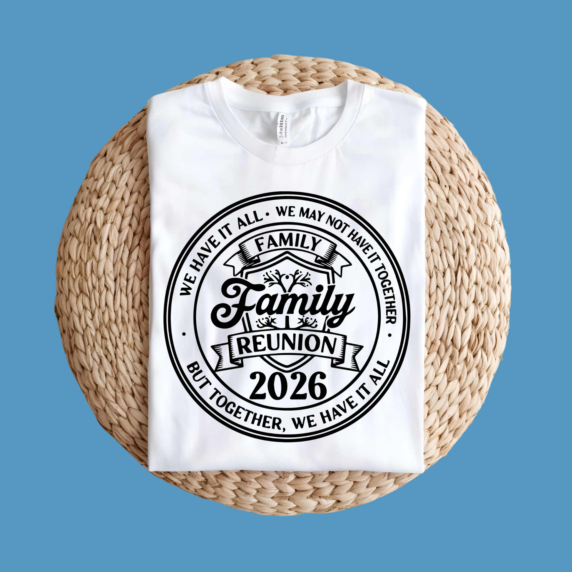 White t-shirt with 'Family Reunion 2026' design on a woven mat against a blue background