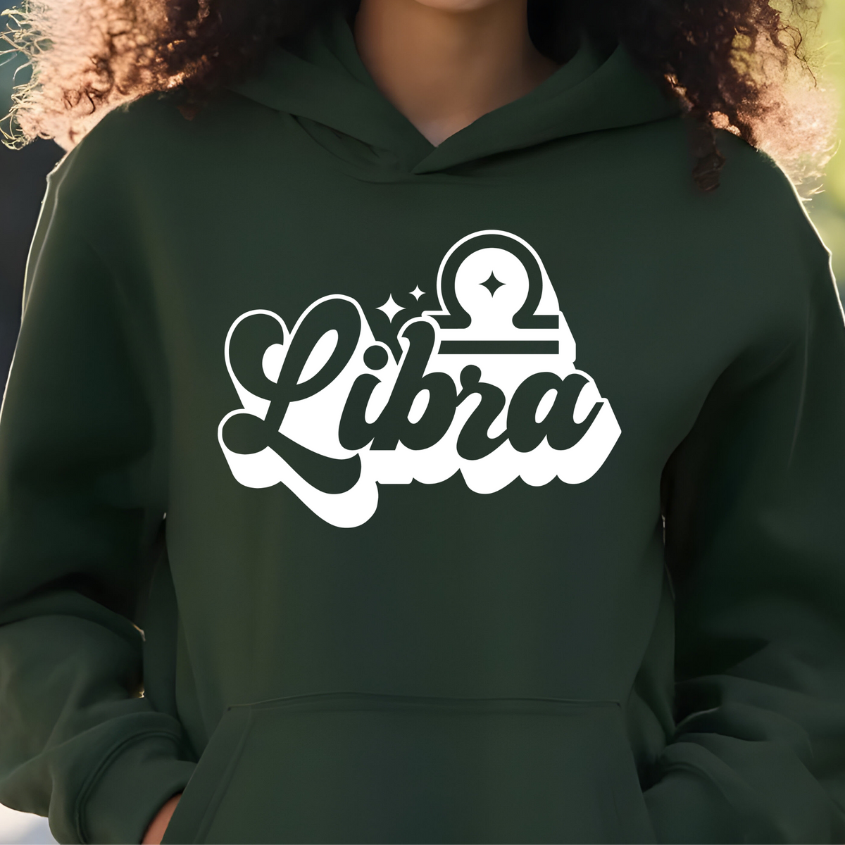 A person wearing a dark forest green hoodie with a white graphic print that reads 'Taurus' in stylized script and includes a Taurus zodiac symbol on the chest.