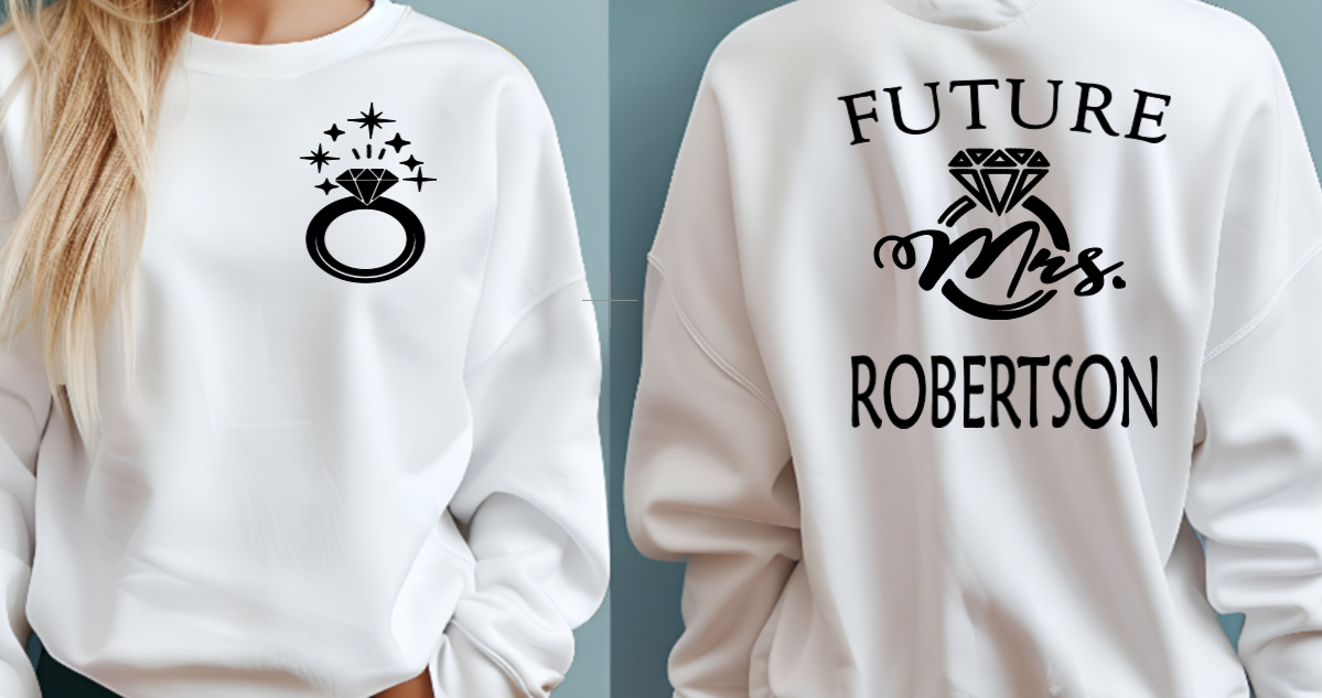 Woman wearing white sweater with FUTURE Mrs. on the back with bling ring on the front indicating engagement announcement shirt for bridal shower or engagement party and gift for new bride to be. 
