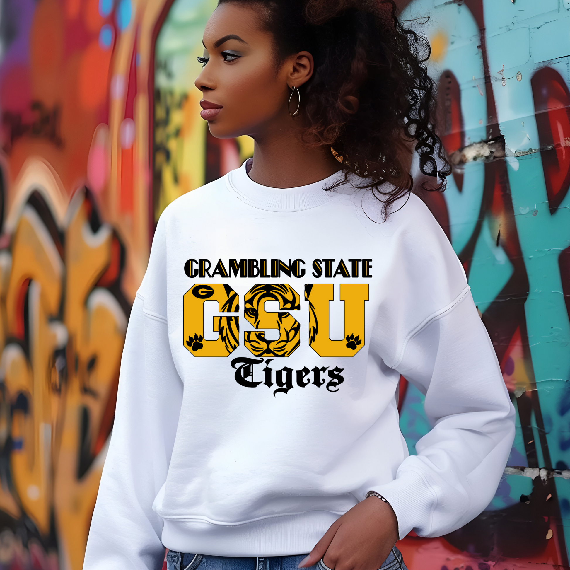 Person wearing a white sweatshirt with 'Gamboling State GSU Tigers' text in front of a graffiti wall.  GSU Tigers Sweatshirt: HBCU Game Day Football Cozy Sweater