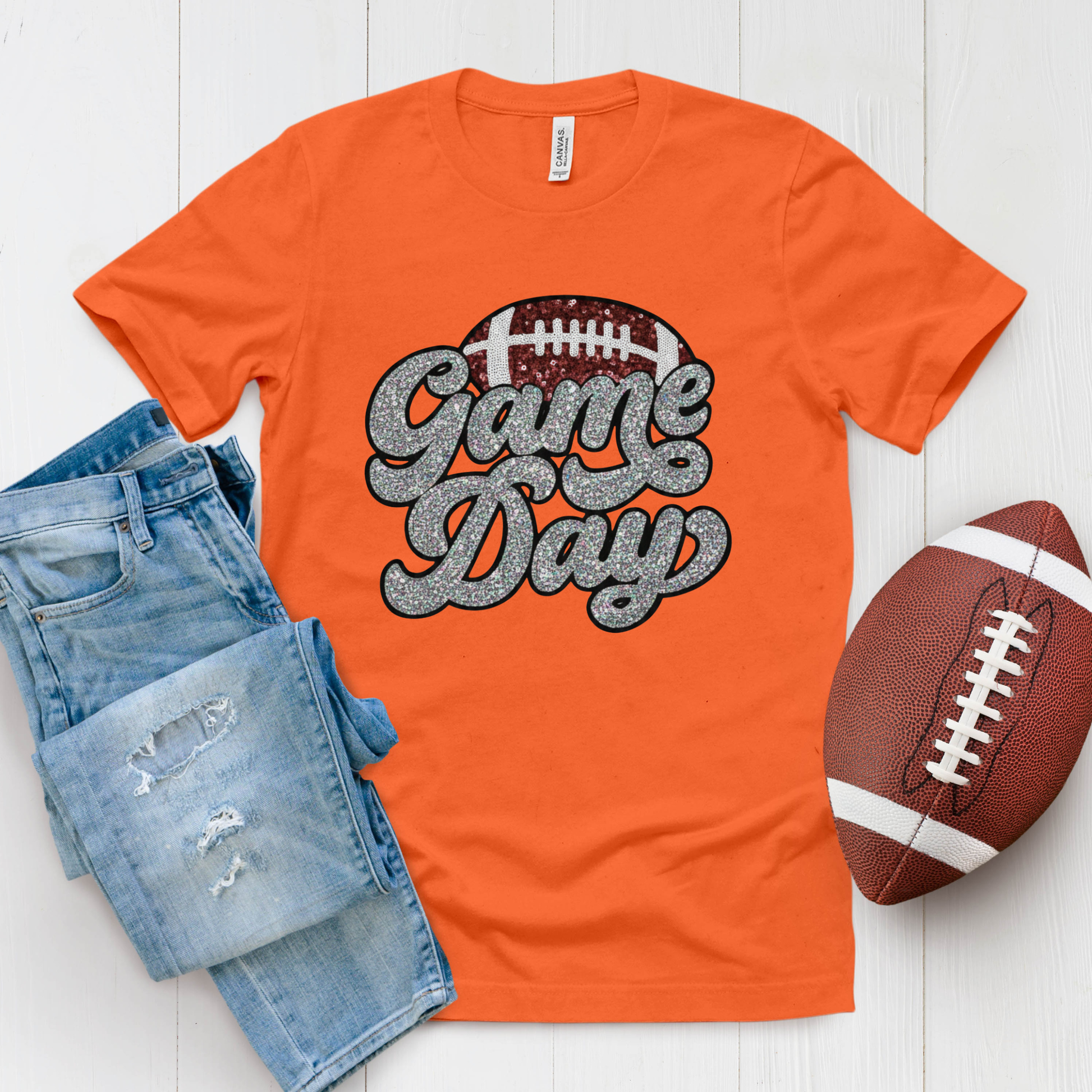 Orange t-shirt with 'Game Day' text, denim shorts, and football on a white background