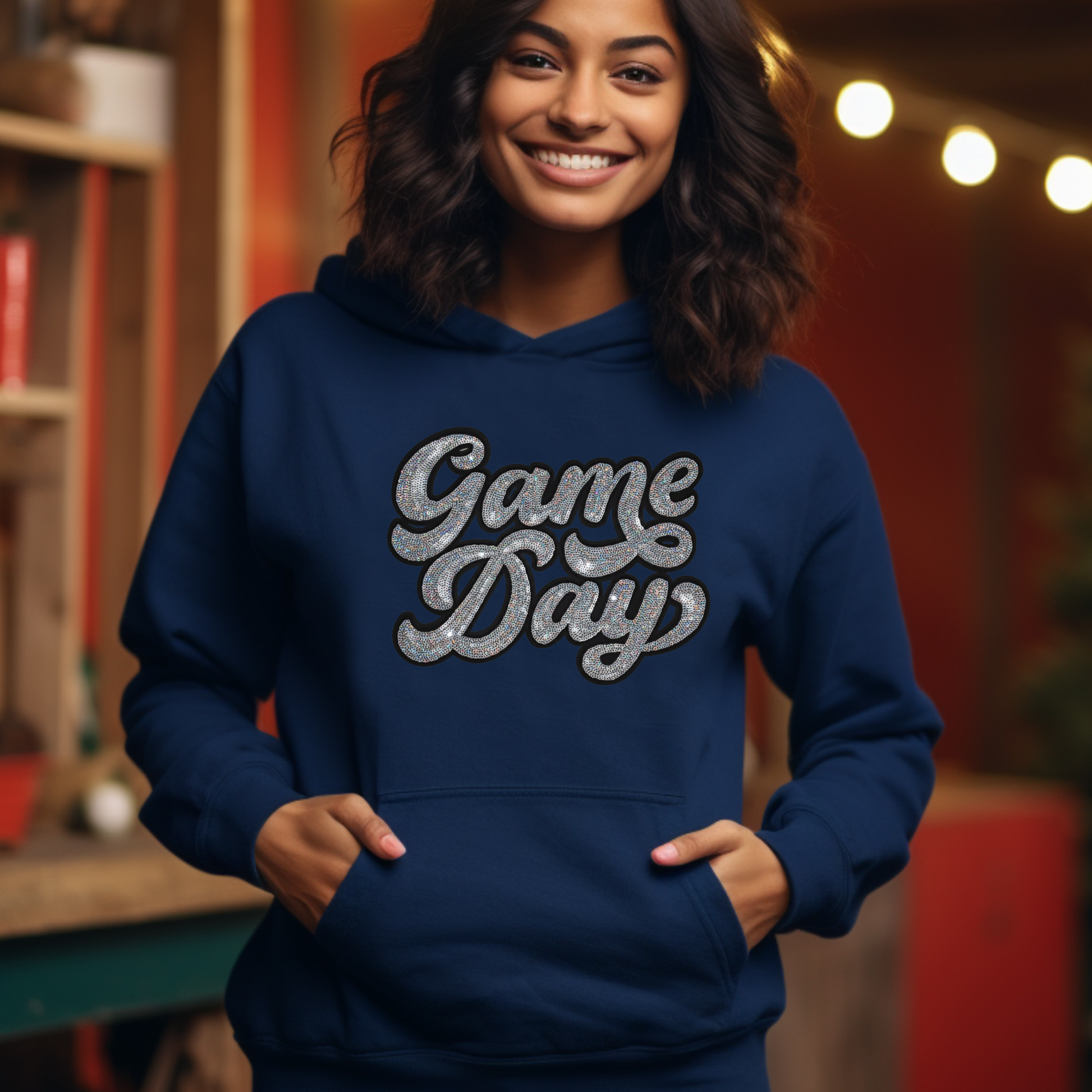 Person wearing a blue 'Game Day' hoodie in an indoor setting with warm lighting.