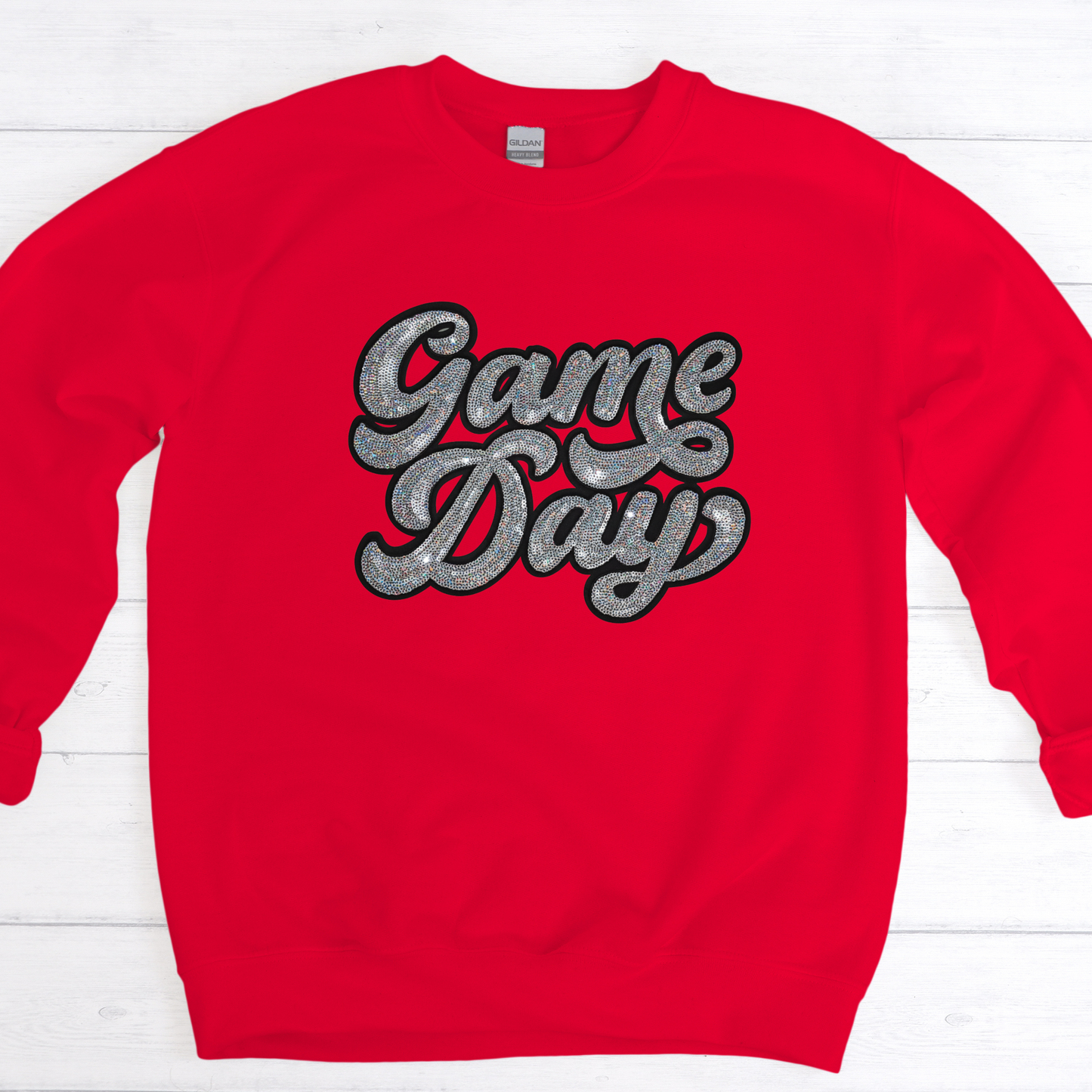 Red sweatshirt with 'Game Day' text on a white wooden background
