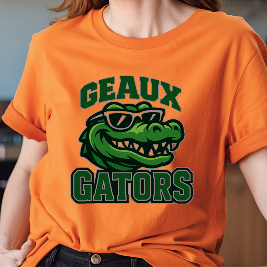 Person wearing an orange t-shirt with a green alligator graphic and 'GEAUX GATORS' text. Gators Mascot Shirt - Geaux Gators Team Pride Shirt