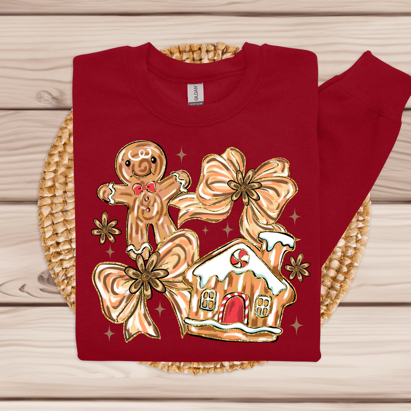 Red sweatshirt with gingerbread man and house design on a woven mat