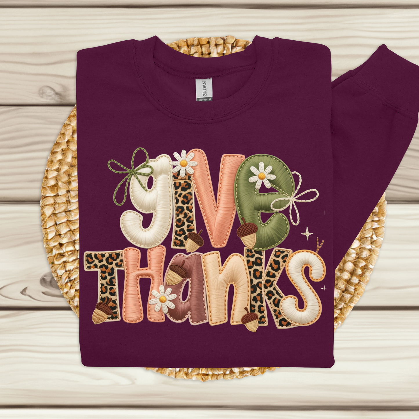 Purple sweatshirt with 'Give Thanks' text on a woven mat
