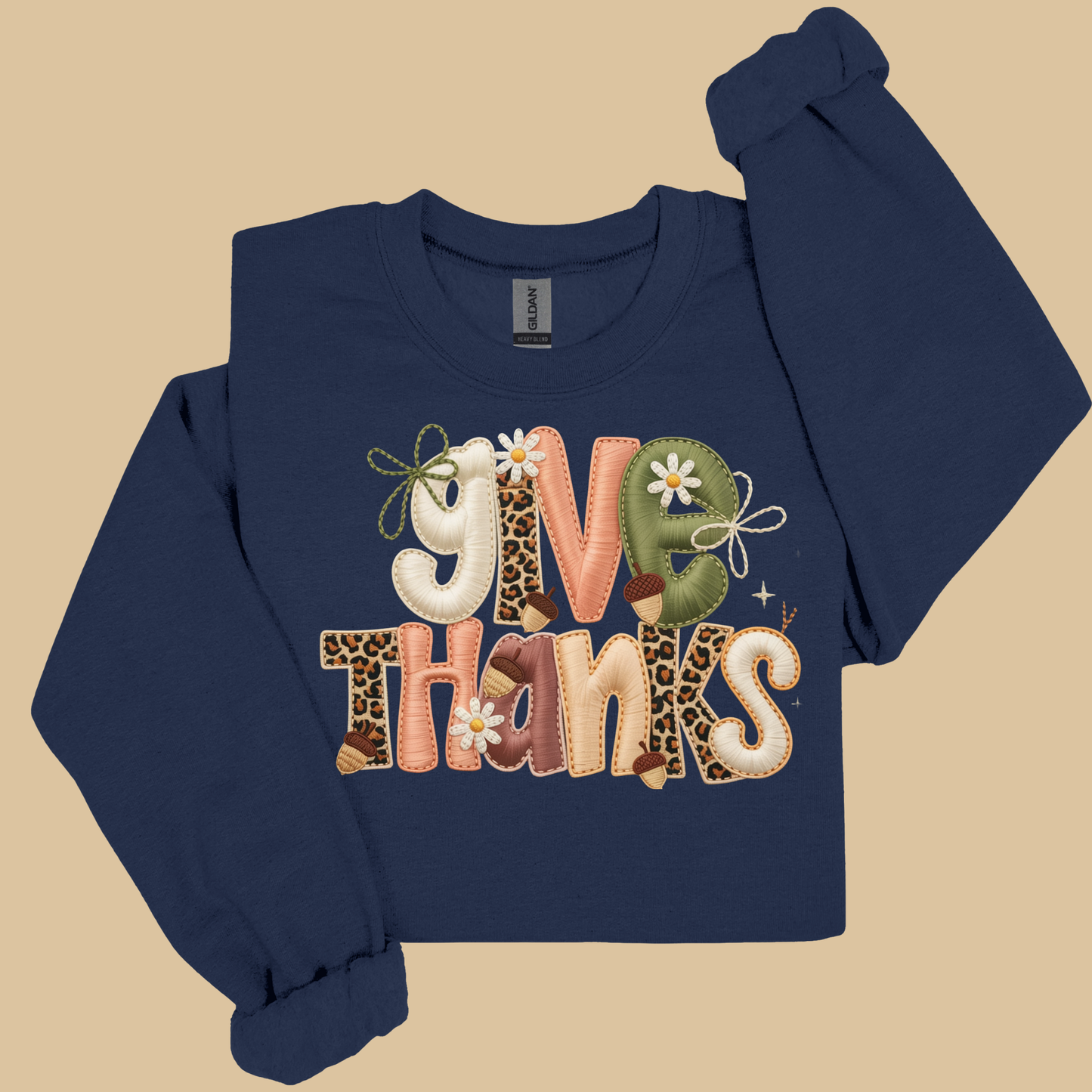 Navy blue sweatshirt with 'Give Thanks' text in colorful letters on a beige background