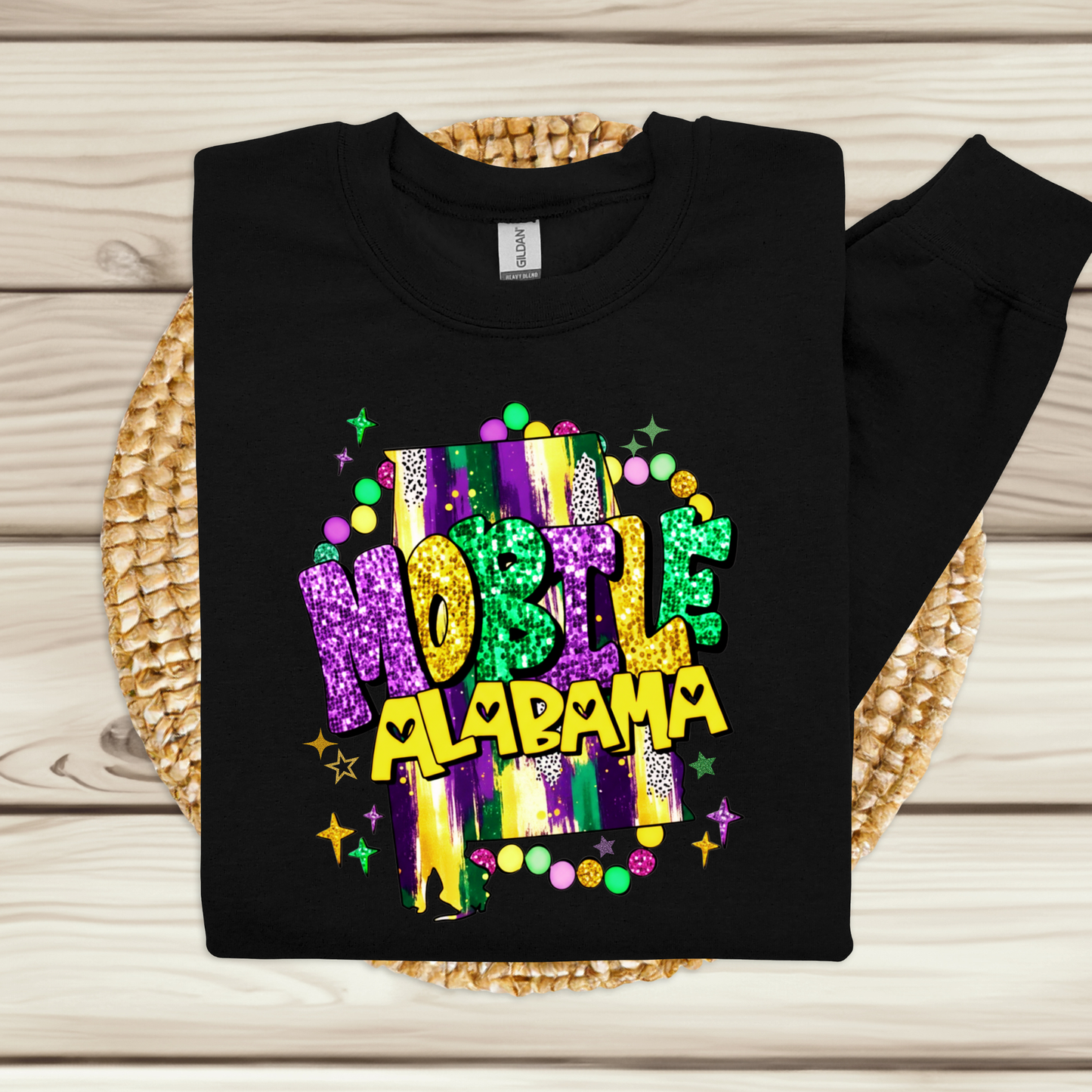 Black sweatshirt with colorful 'Mobile, Alabama' text on a woven mat.
