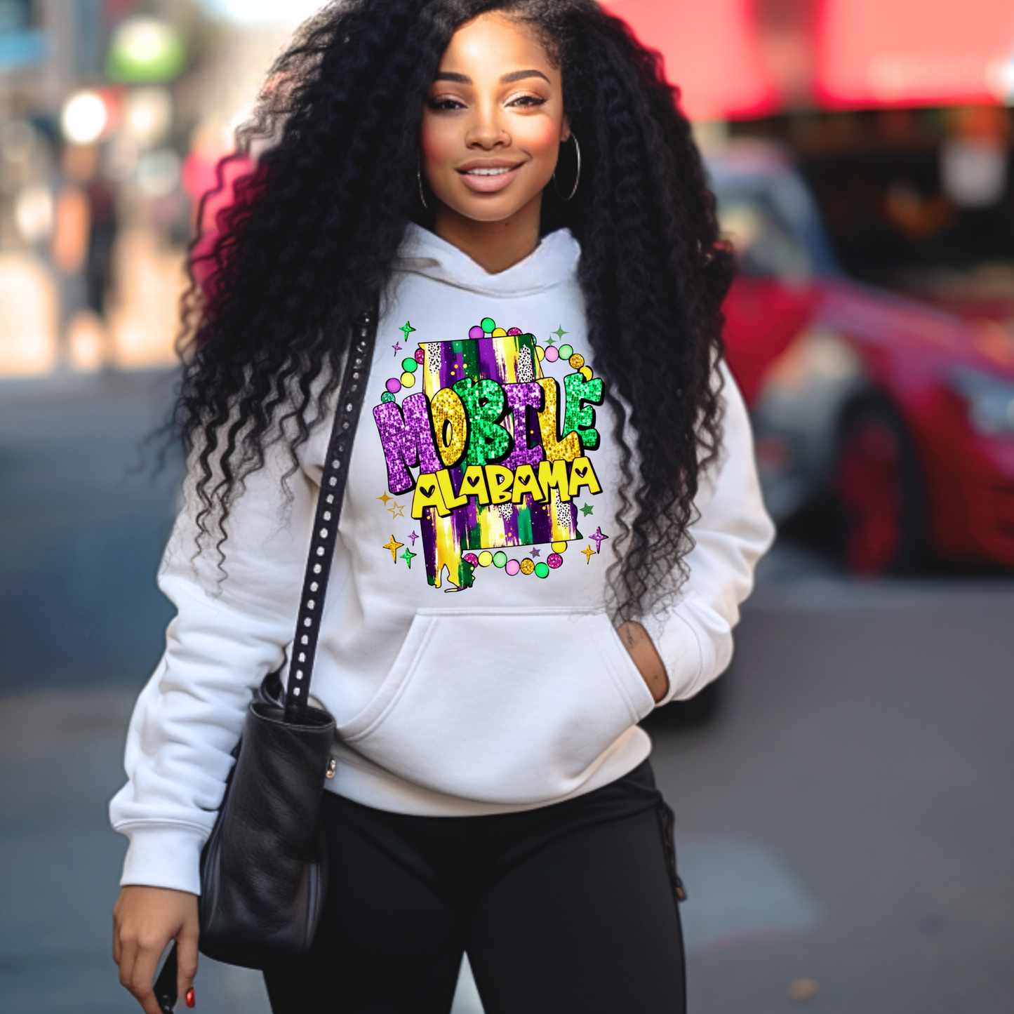 Woman wearing a white hoodie with colorful text, standing on a street.