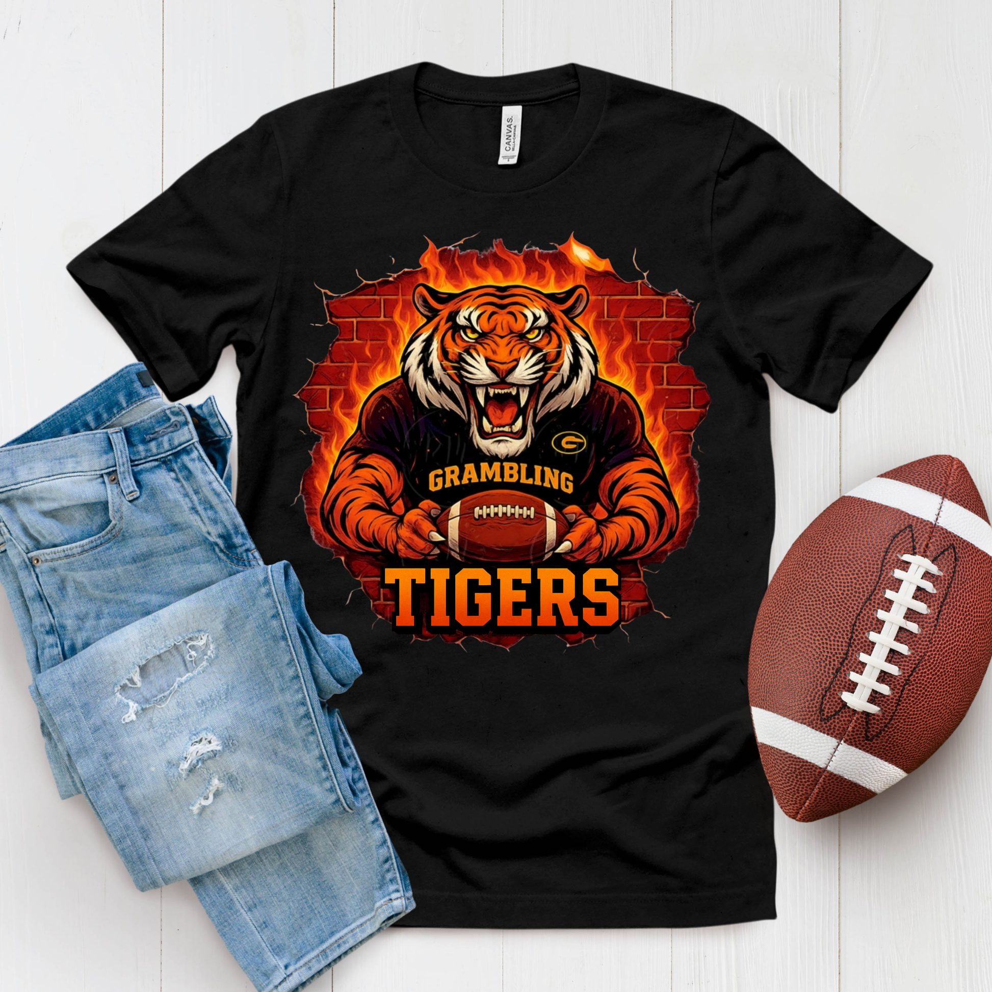 Black t-shirt with tiger graphic and 'Grambling Tigers' text, paired with denim shorts and a football on a white background.