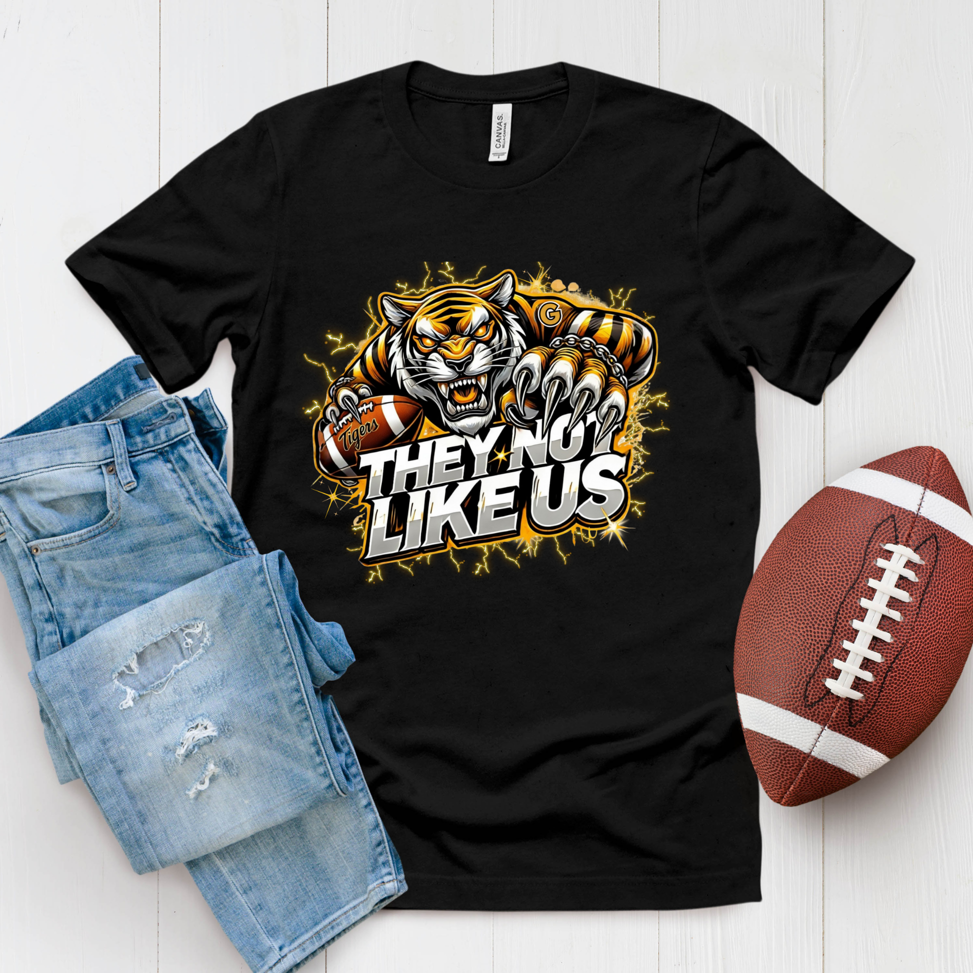 Black t-shirt with tiger graphic and text, paired with denim shorts and a football on a white background