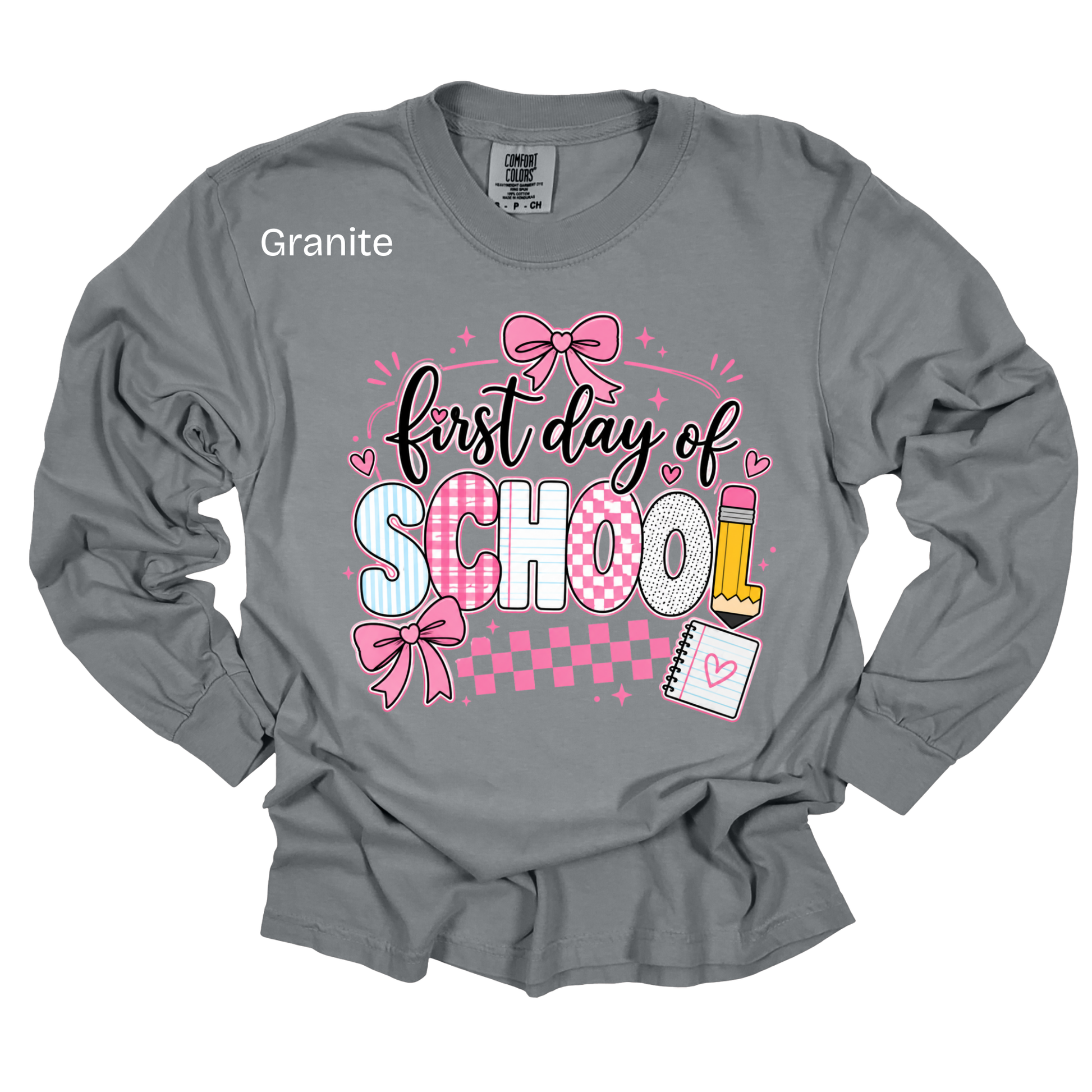 A gray long-sleeve t-shirt with a 'first day of SCHOOL' graphic in pink, white, and black, featuring school-themed illustrations like bows, a pencil, and a notebook. The word 'Granite' is printed on the upper left chest.