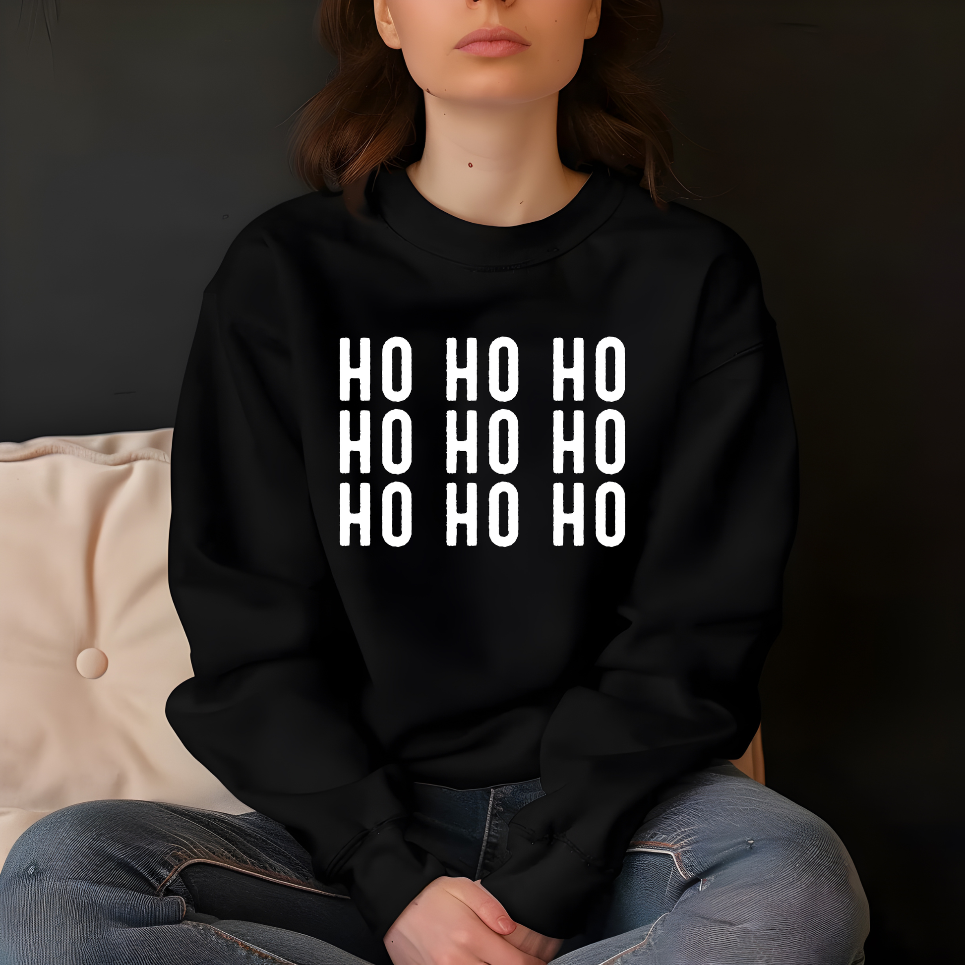 Person wearing a black hoodie with 'HO HO HO' text sitting on a couch.