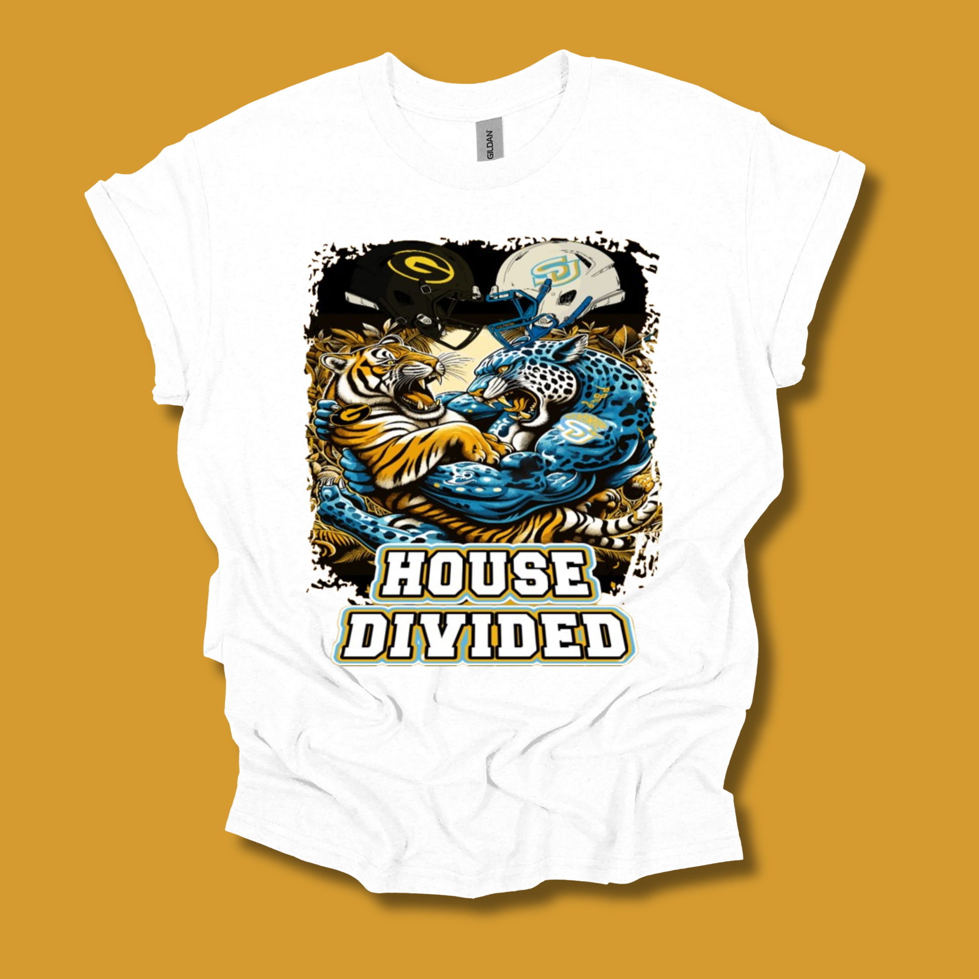 A white short-sleeve graphic t-shirt laid flat against a solid mustard yellow background. The shirt features a detailed graphic print of a tiger and a blue leopard mascot holding football helmets, with the text 'HOUSE DIVIDED' printed below in white with a black outline.