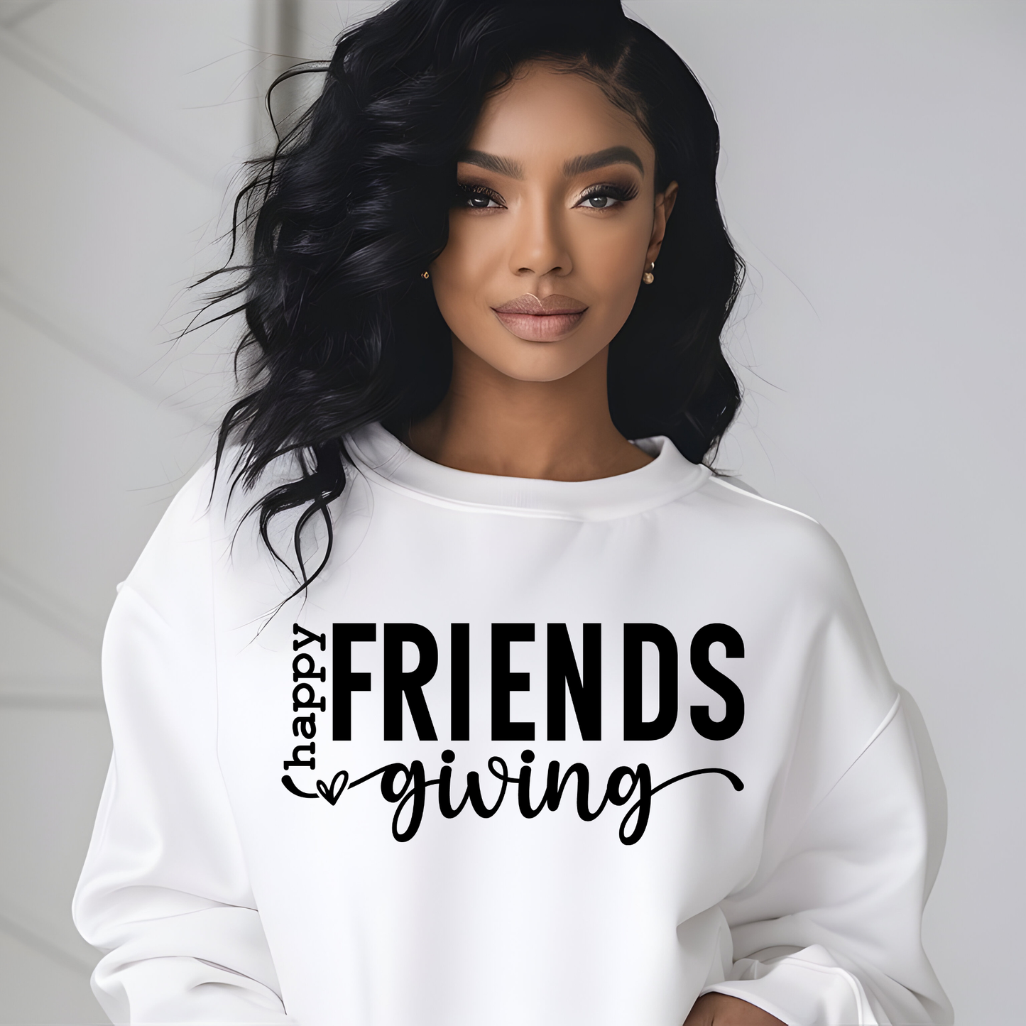 Woman wearing a white sweatshirt with 'Happy Friendsgiving' text on a plain background