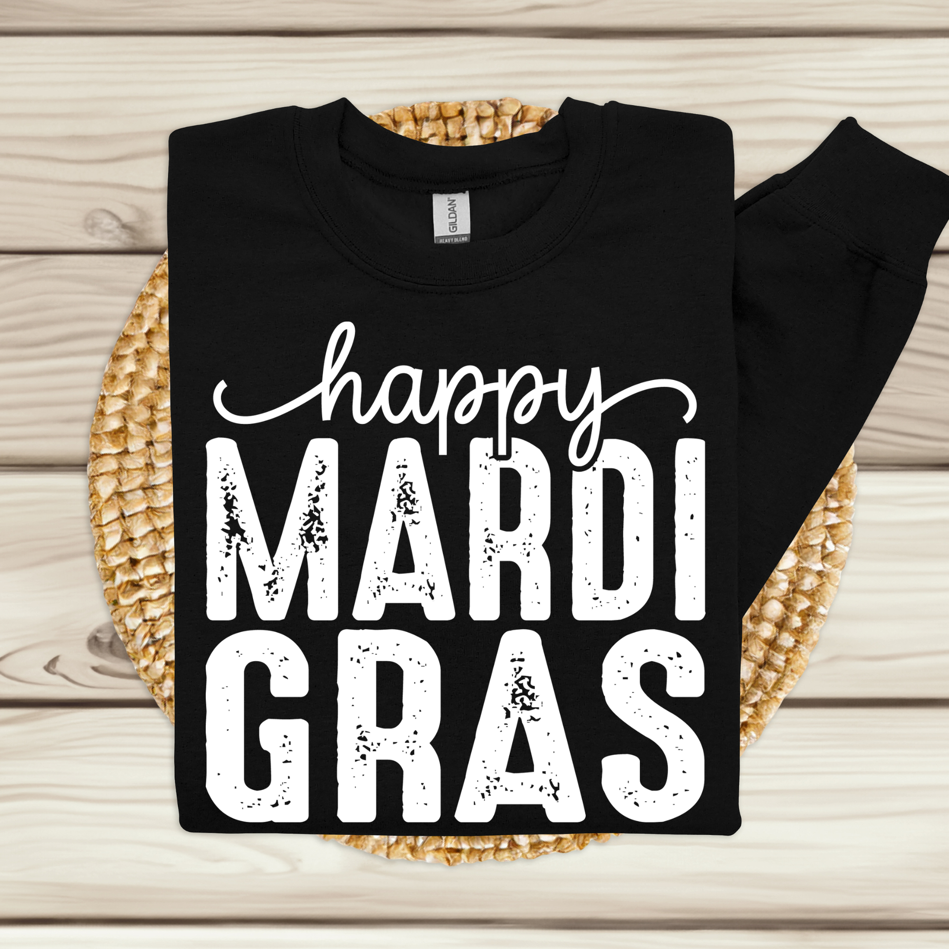 Black sweatshirt with 'happy MARDI GRAS' text on a woven mat