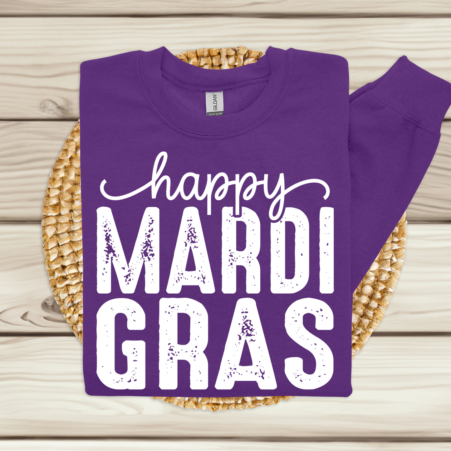 Purple shirt with 'happy MARDI GRAS' text on a woven mat