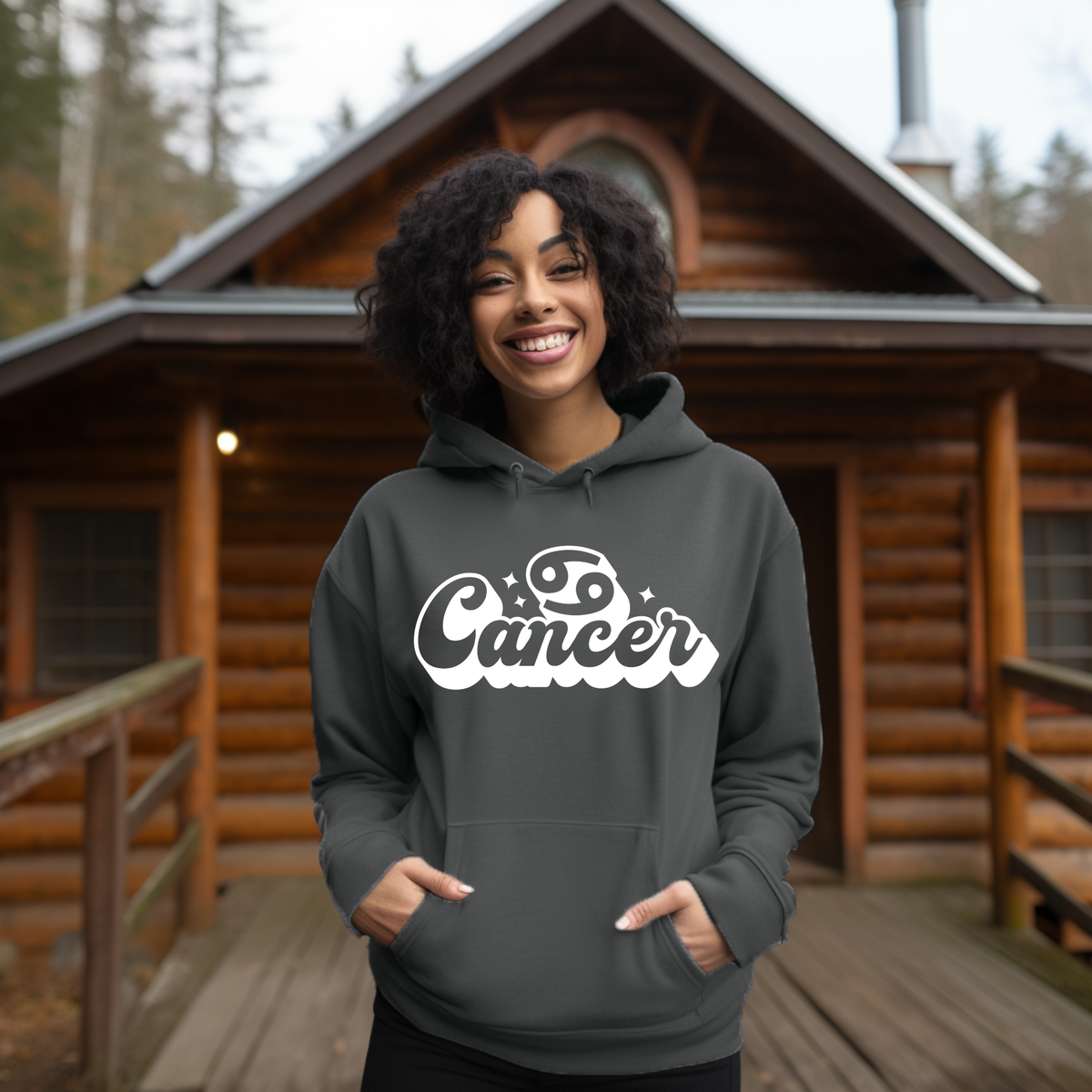 A woman wearing a dark gray hoodie with a white 'Capricorn' graphic on the chest, sitting on a couch.