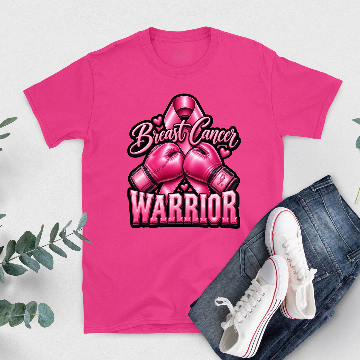 A bright pink short-sleeve T-shirt with bold white text reading 'FIGHT LIKE A QUEEN' laid flat on a light background, styled with blue jeans and white sneakers with red stripes.