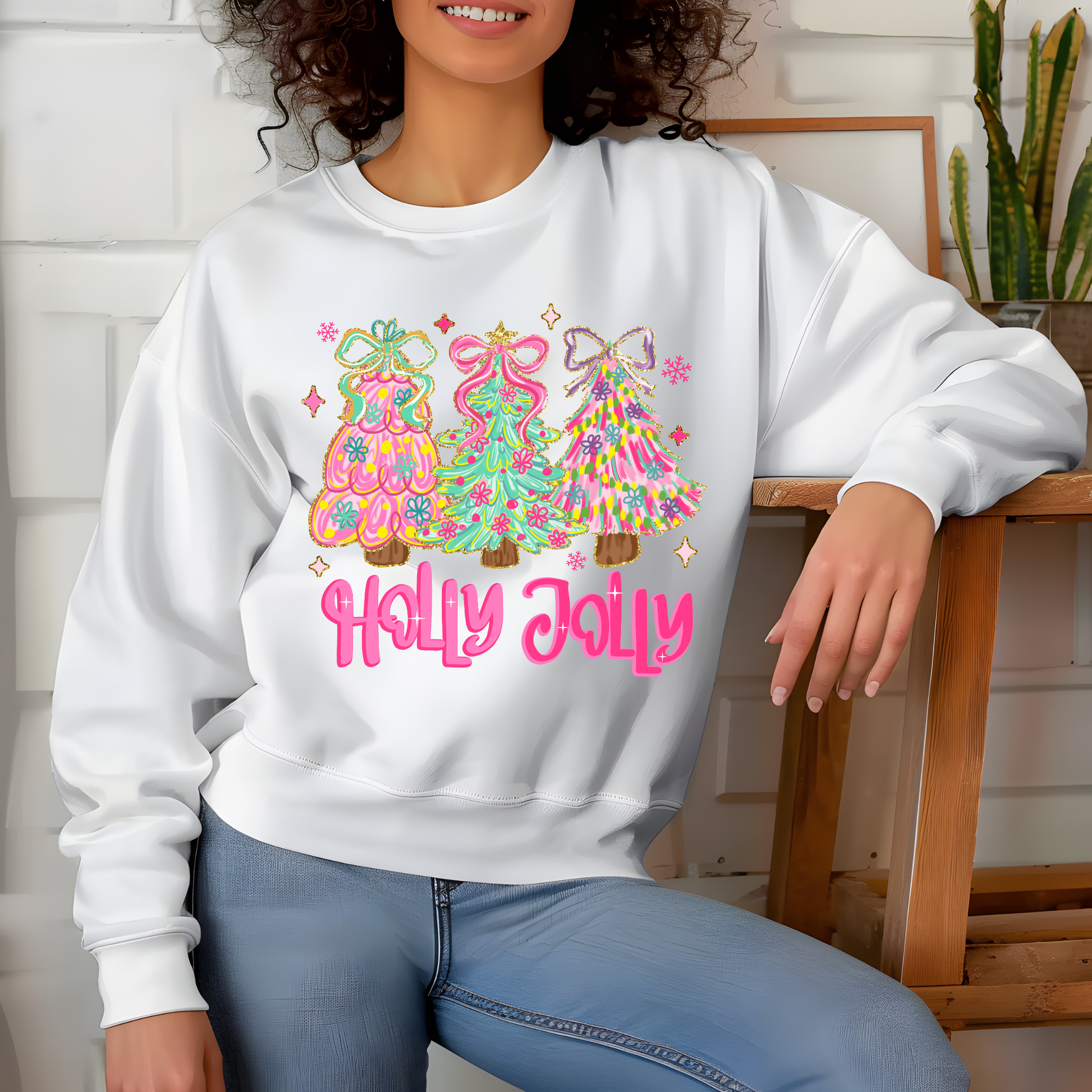 Person wearing a white sweatshirt with colorful Christmas tree design and 'Holly Jolly' text.