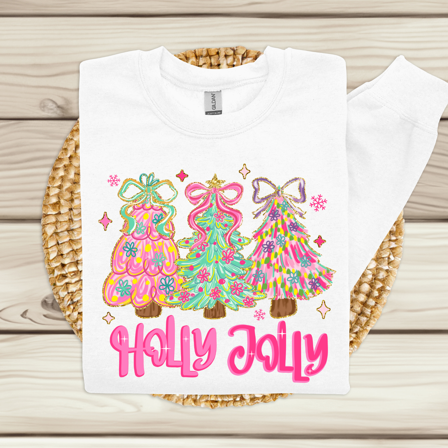 White t-shirt with colorful Christmas tree design and 'Holly Jolly' text on a wooden surface.